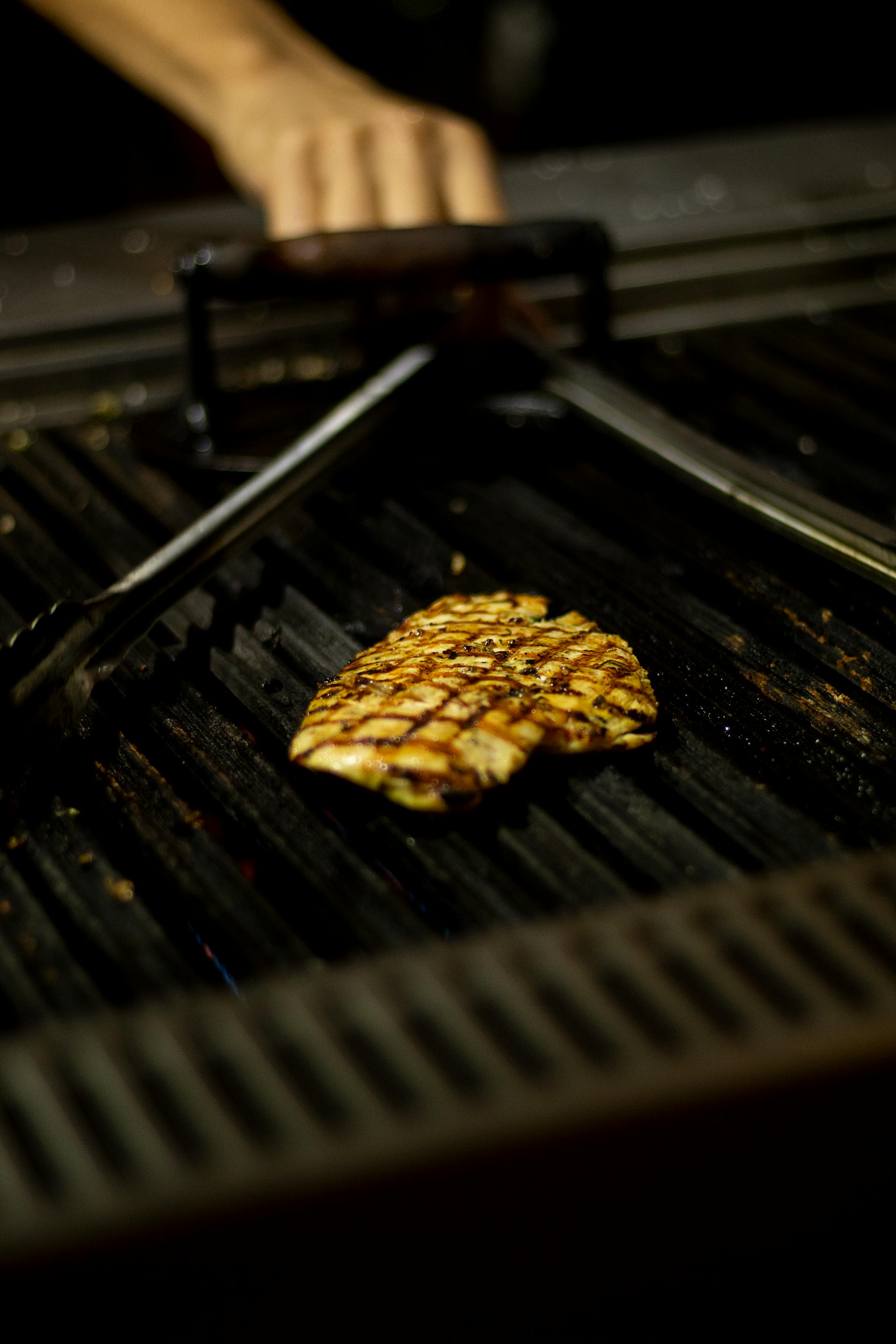 Eine Hähnchenbrust, die auf einem Grill gegart wird | Quelle: Pexels