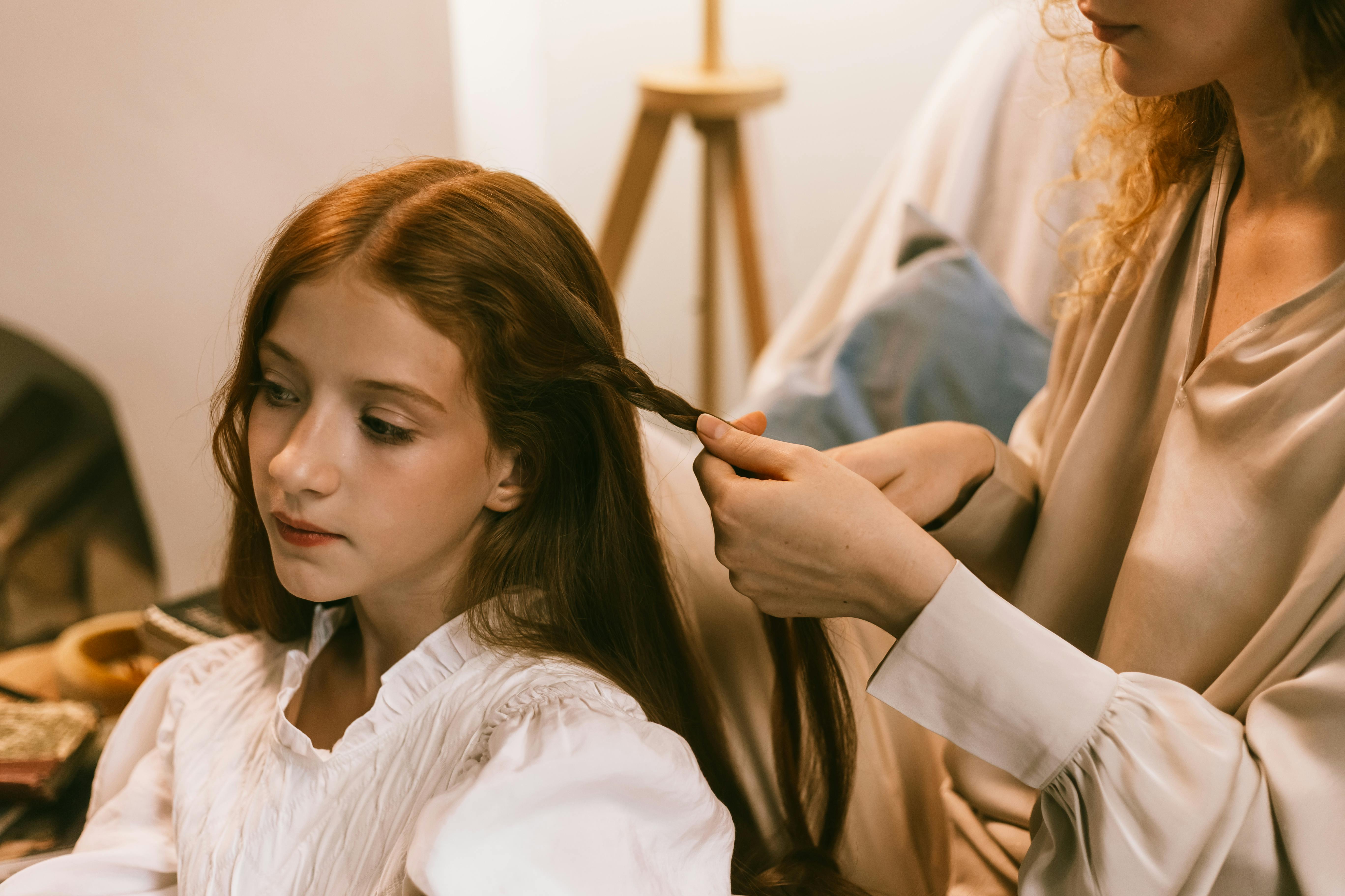 Eine Mutter frisiert die Haare ihrer Tochter | Quelle: Pexels