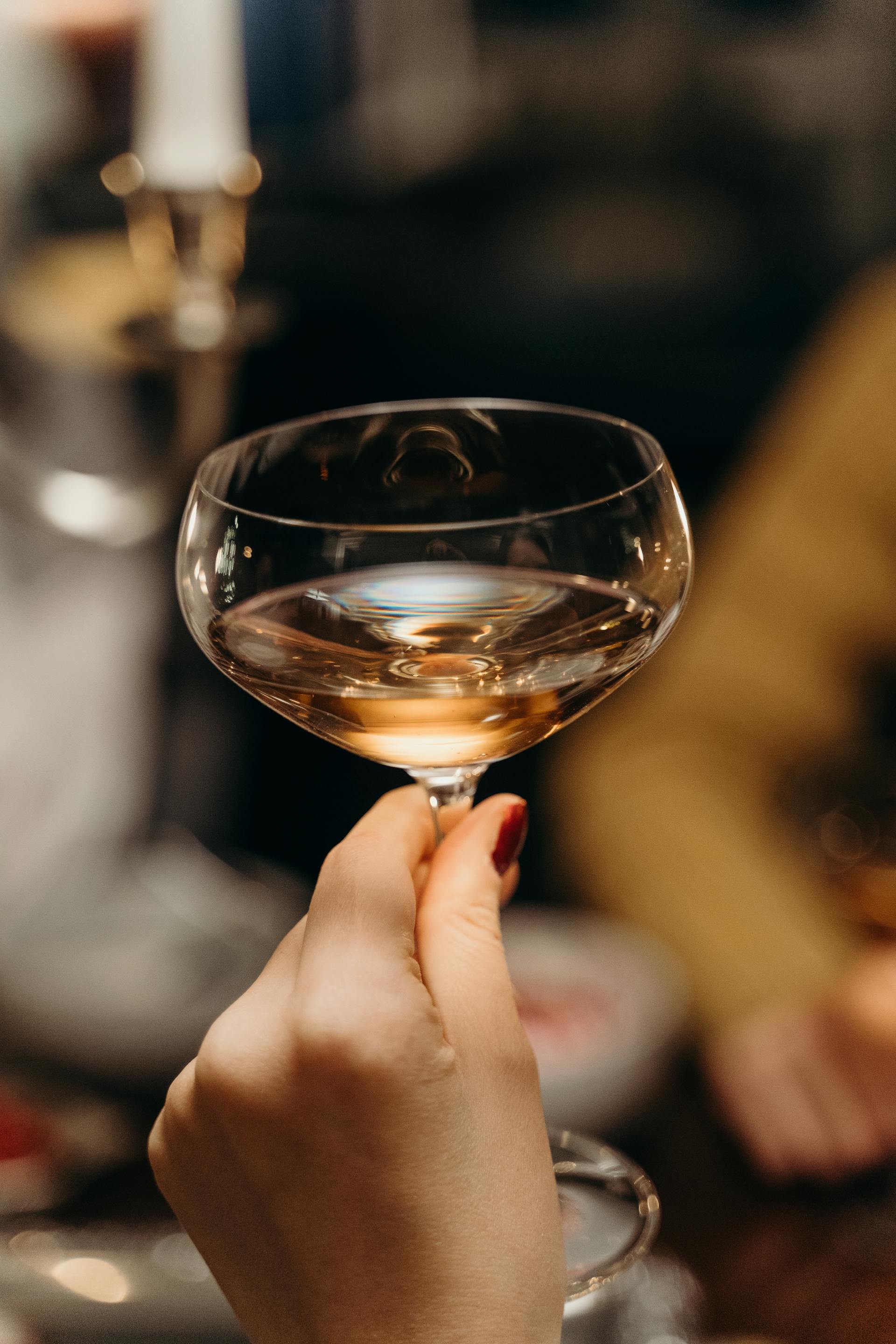 Eine Nahaufnahme einer Frau, die ein Glas Champagner hält | Quelle: Pexels