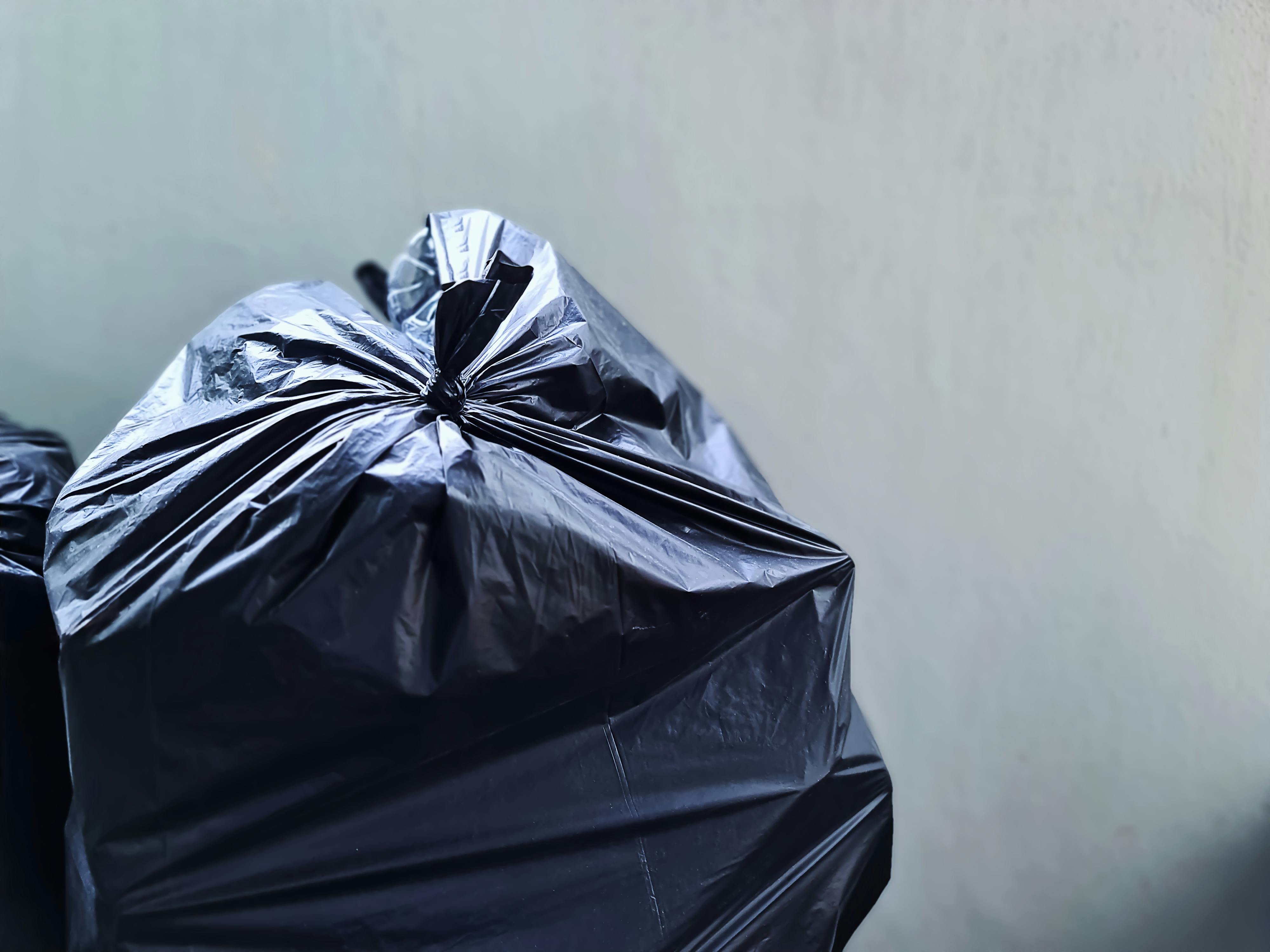 Schwarze Plastiktüte an einer Betonwand | Quelle: Pexels