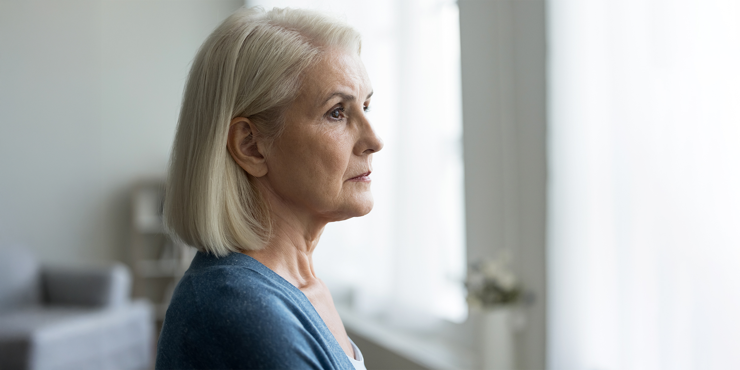 Eine angespannte Frau, die aus dem Fenster starrt | Quelle: Shutterstock