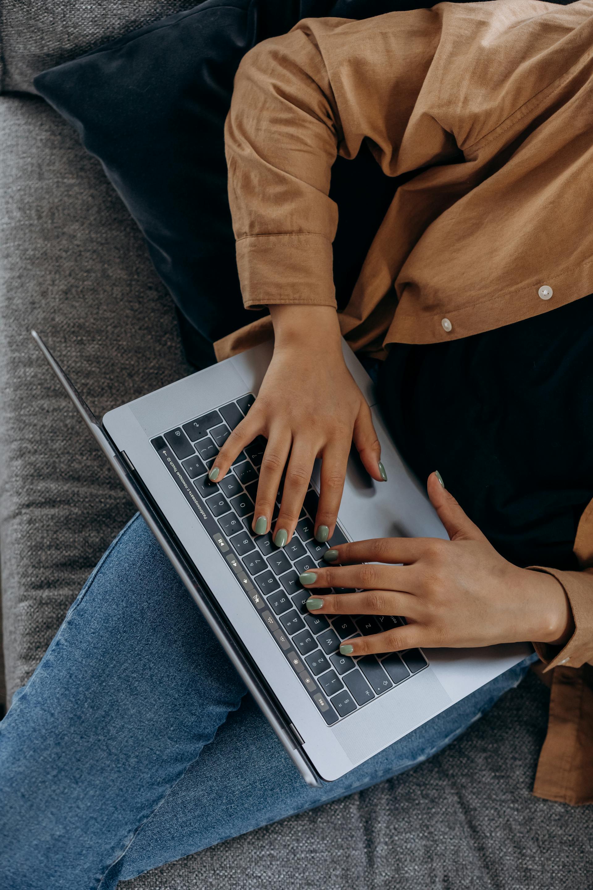 Eine Nahaufnahme einer Frau, die an ihrem Laptop arbeitet | Quelle: Pexels