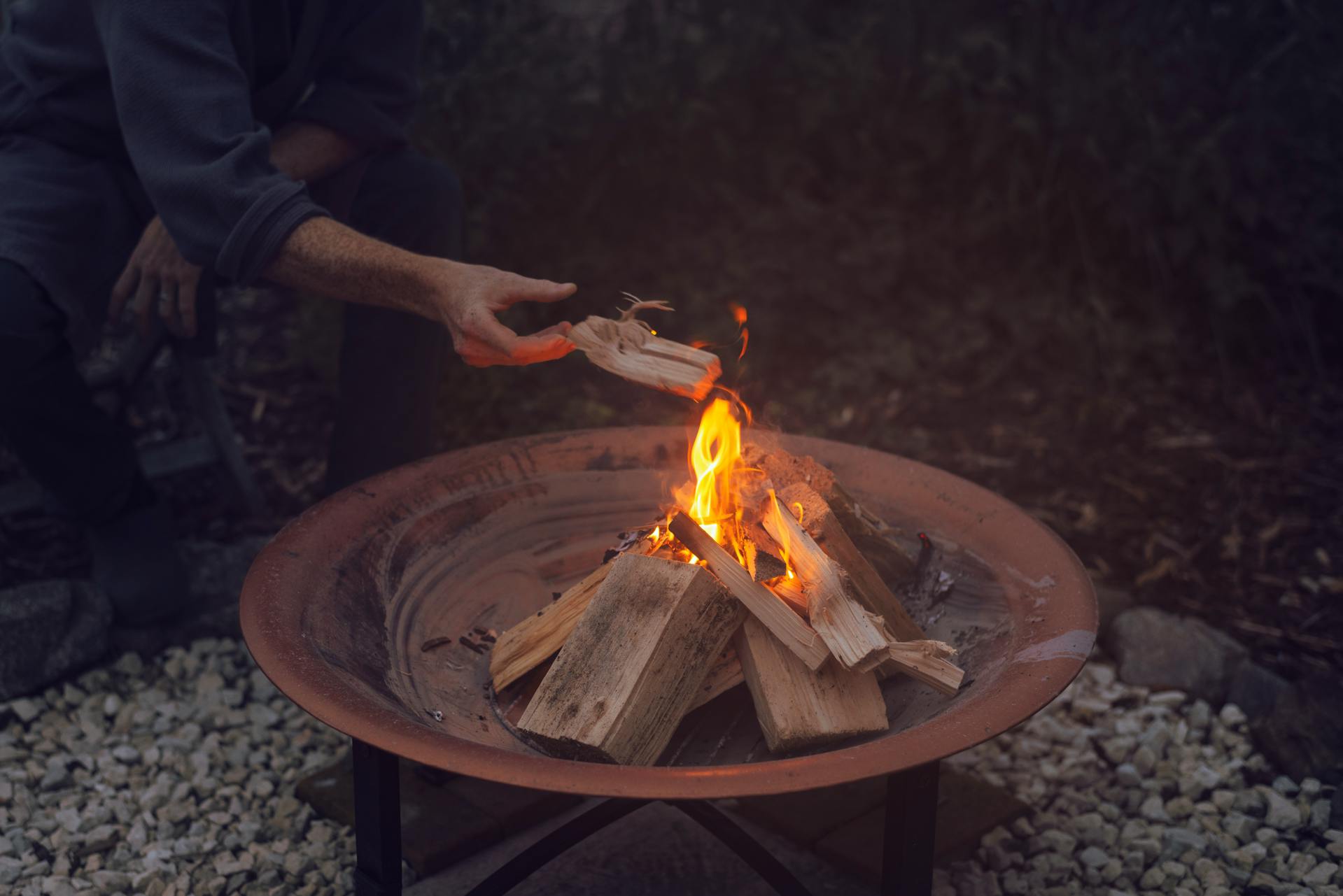 Ein Mann zündet eine Feuerstelle an | Quelle: Pexels