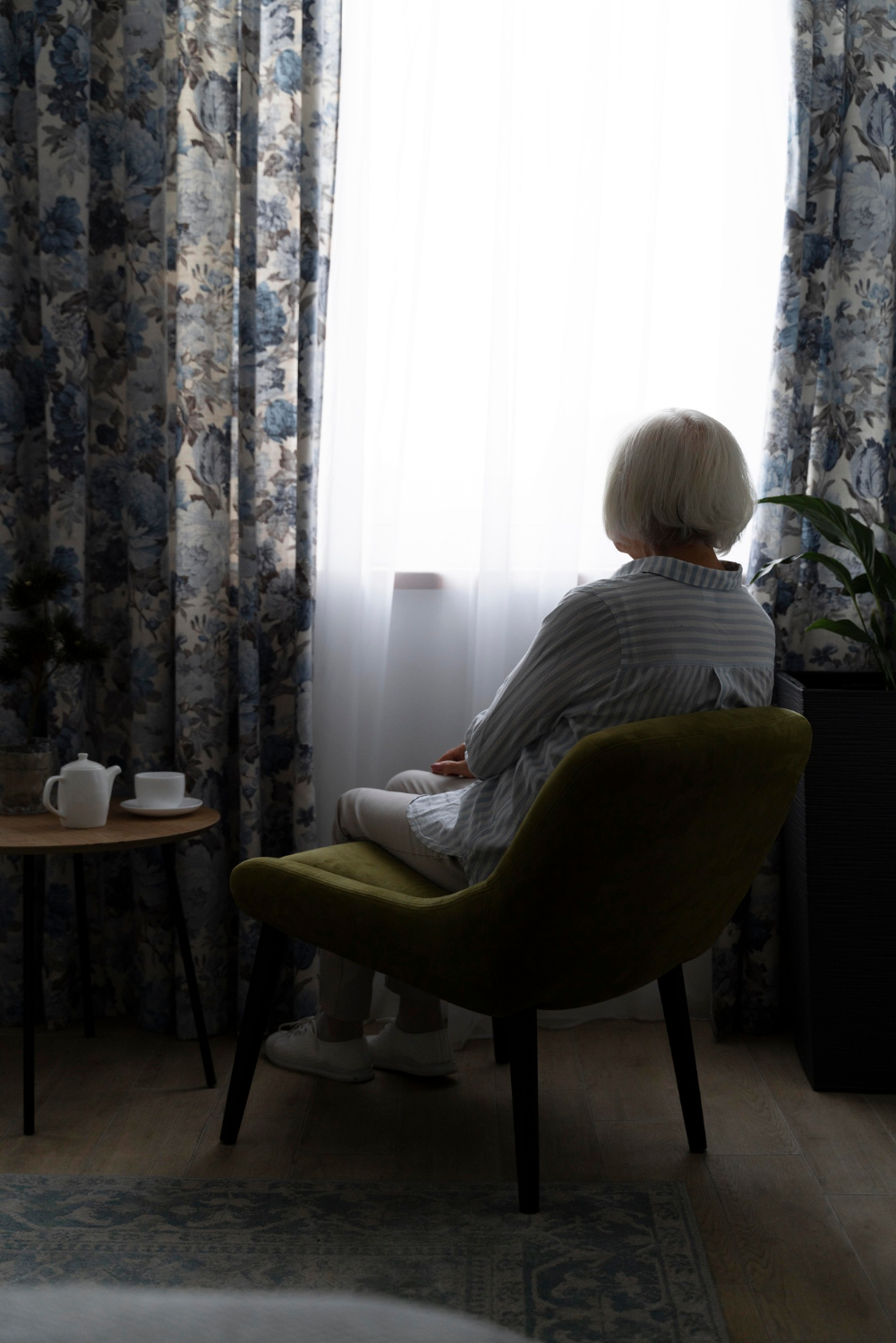 Eine einsame ältere Frau sitzt in einem Zimmer | Quelle: Freepik