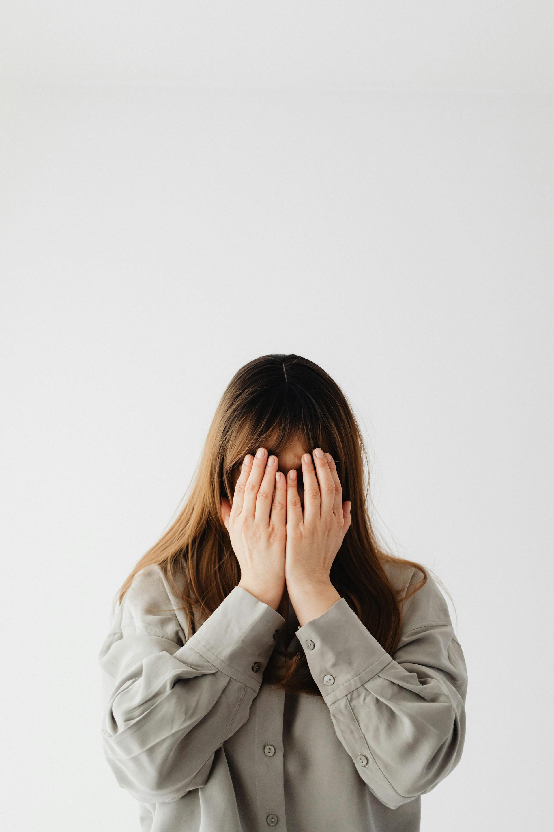 Eine Frau, die ihr Gesicht mit ihren Händen bedeckt | Quelle: Pexels