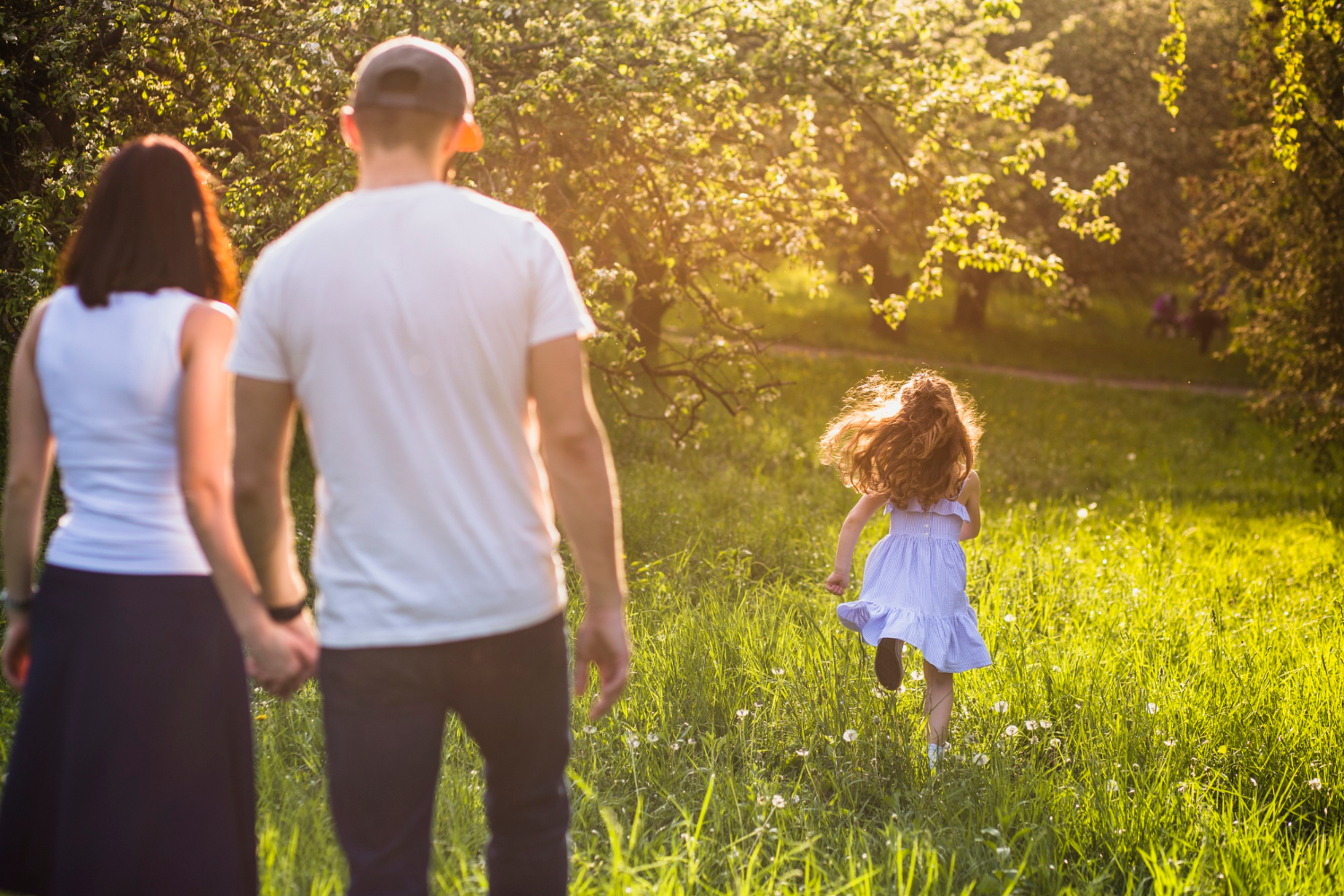Ein Paar beobachtet seine Tochter beim Laufen im Park | Quelle: Freepik