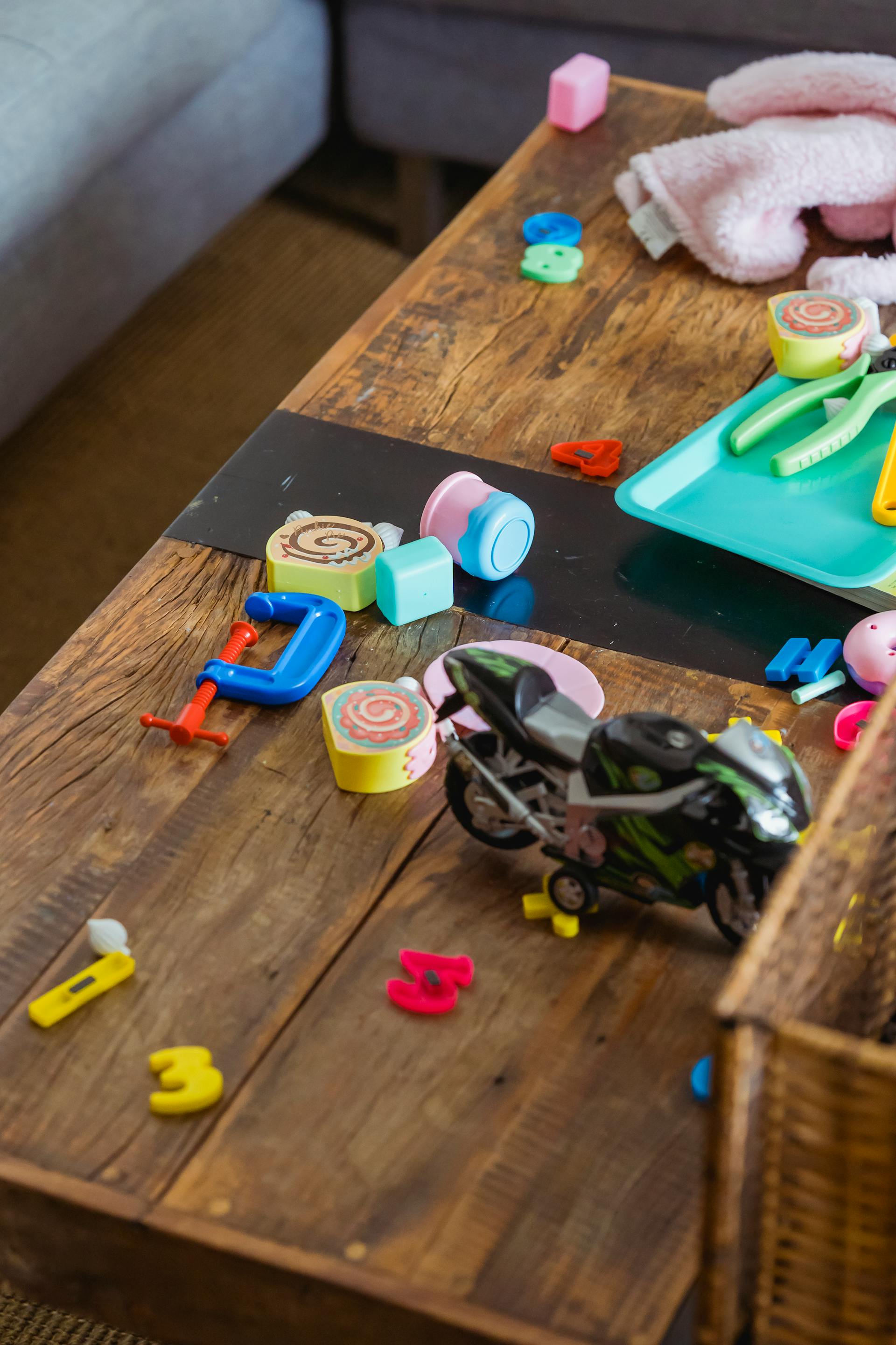 Verstreute Spielsachen auf einer Holztischoberfläche | Quelle: Pexels