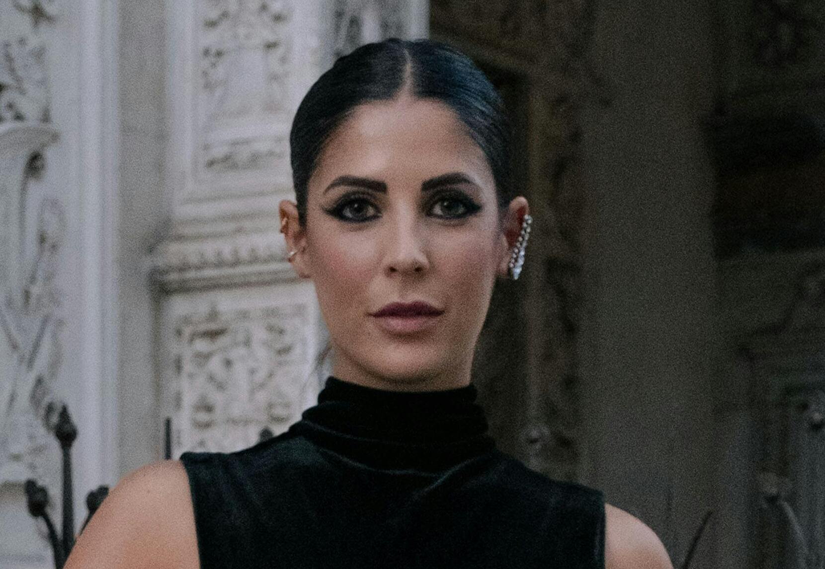 Eine Frau in einem schwarzen Samtkleid mit ernster Miene | Quelle: Pexels