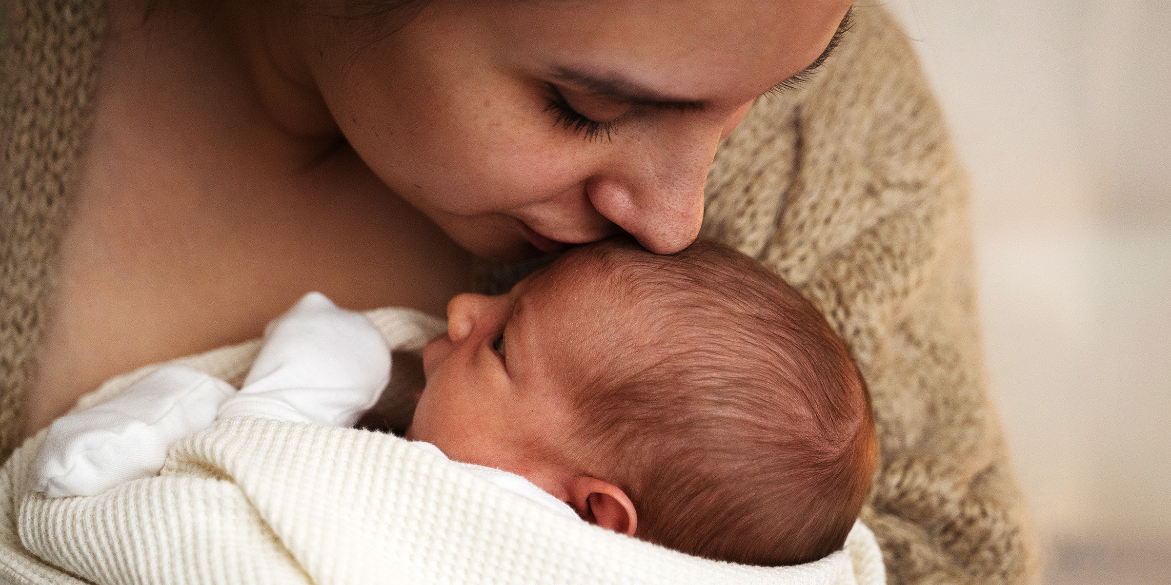 Eine Frau, die ihr Baby küsst | Quelle: Freepik