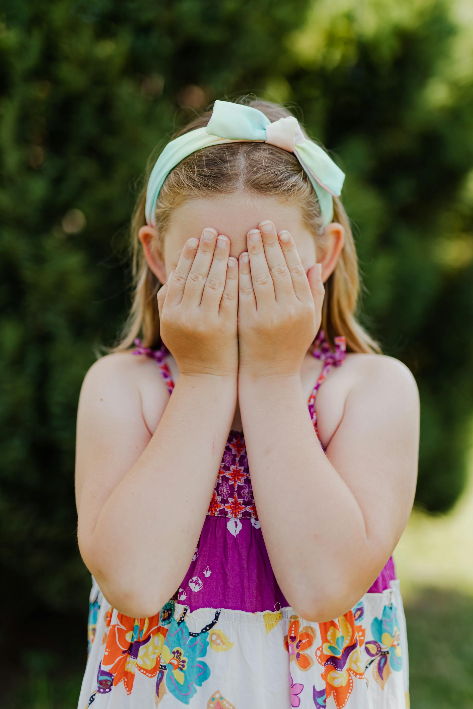 Ein kleines Mädchen, das sein Gesicht mit den Händen bedeckt | Quelle: Pexels