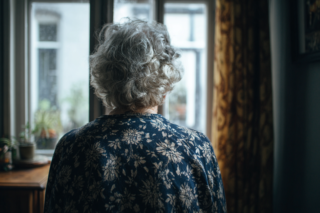 Eine ältere Frau, die an einem Fenster steht | Quelle: Midjourney