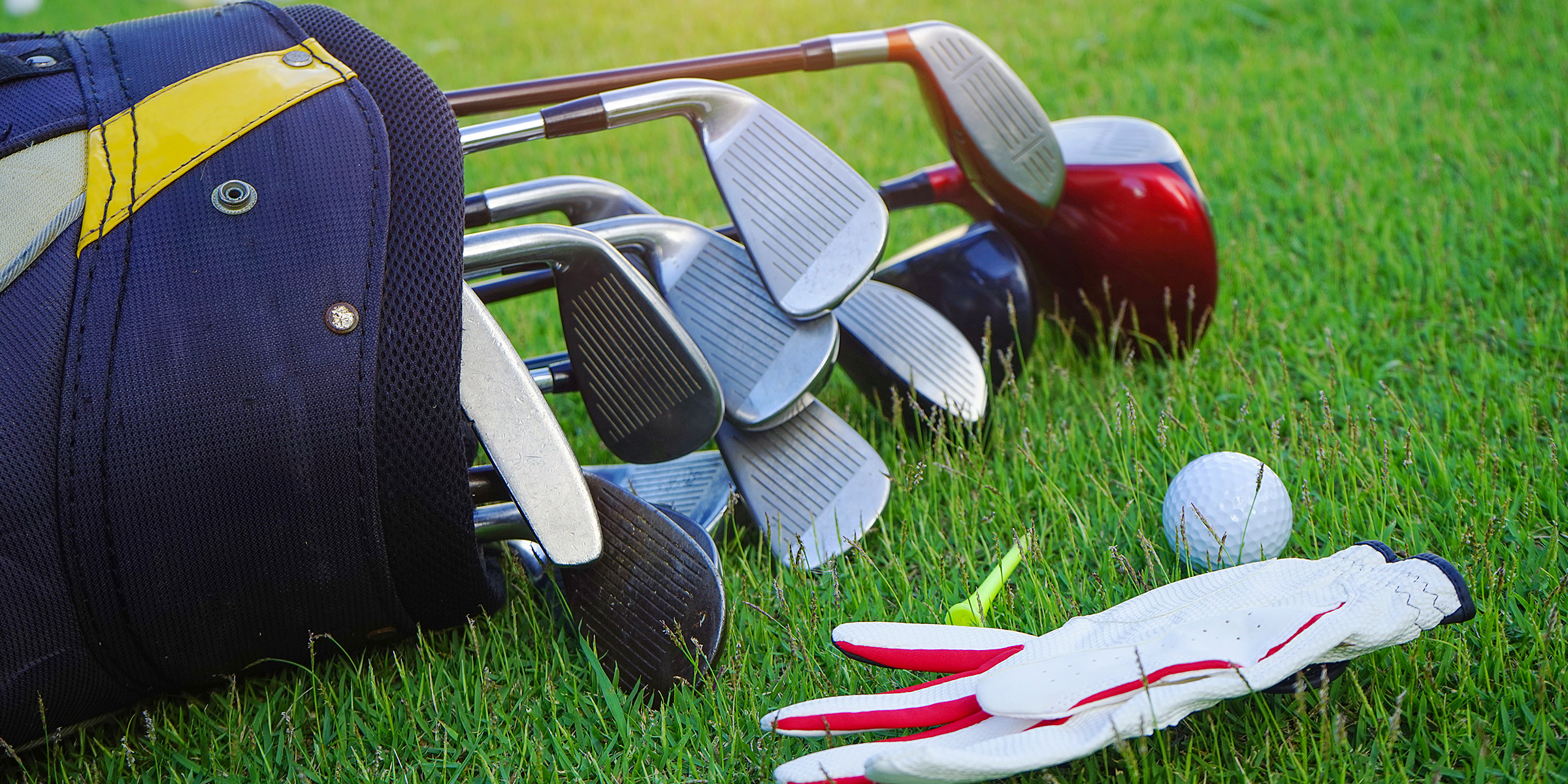 Ein Satz Golfschläger und ein Golfball liegen auf dem Gras | Quelle: Shutterstock