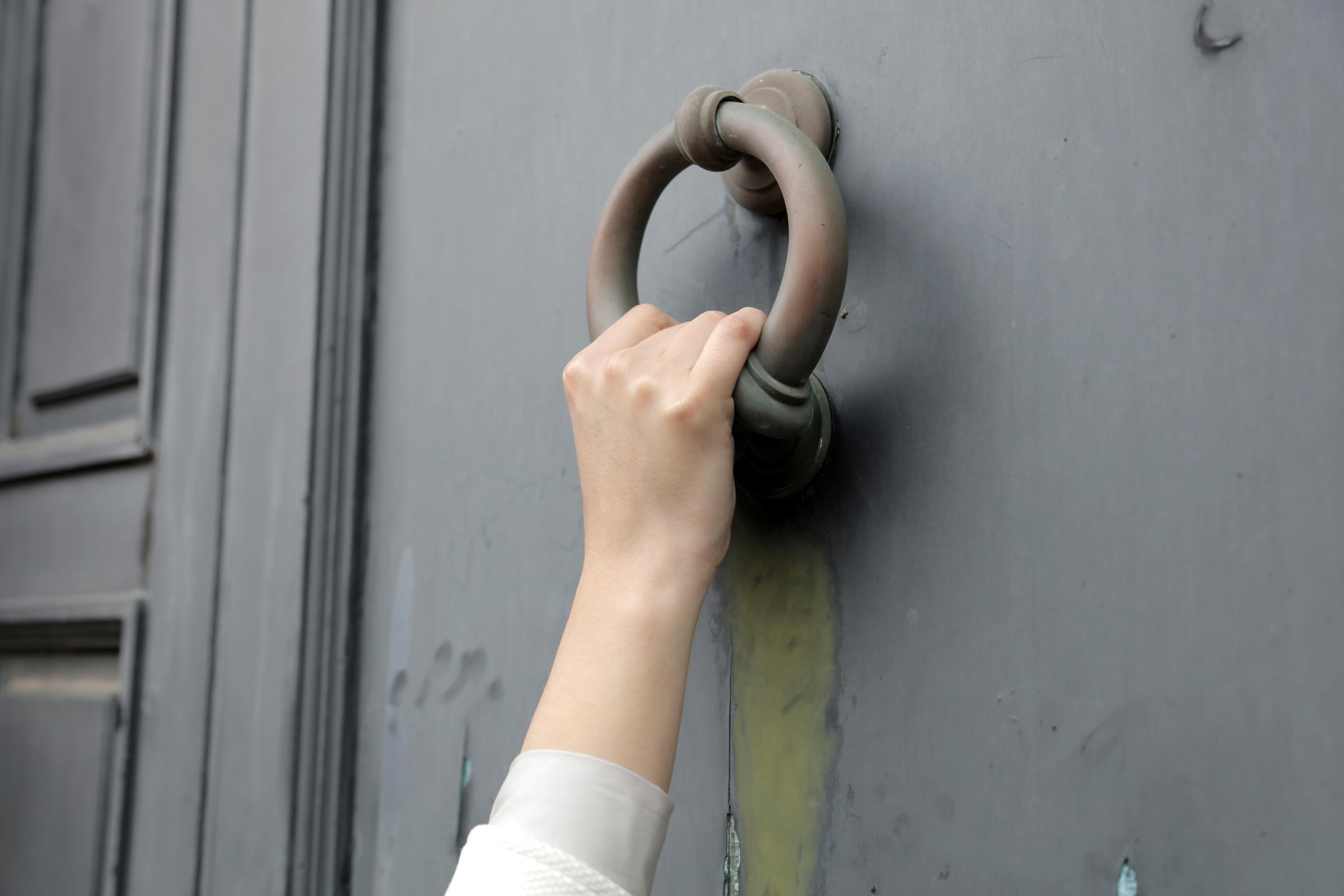 Eine Hand klopft an eine Tür | Quelle: Freepik