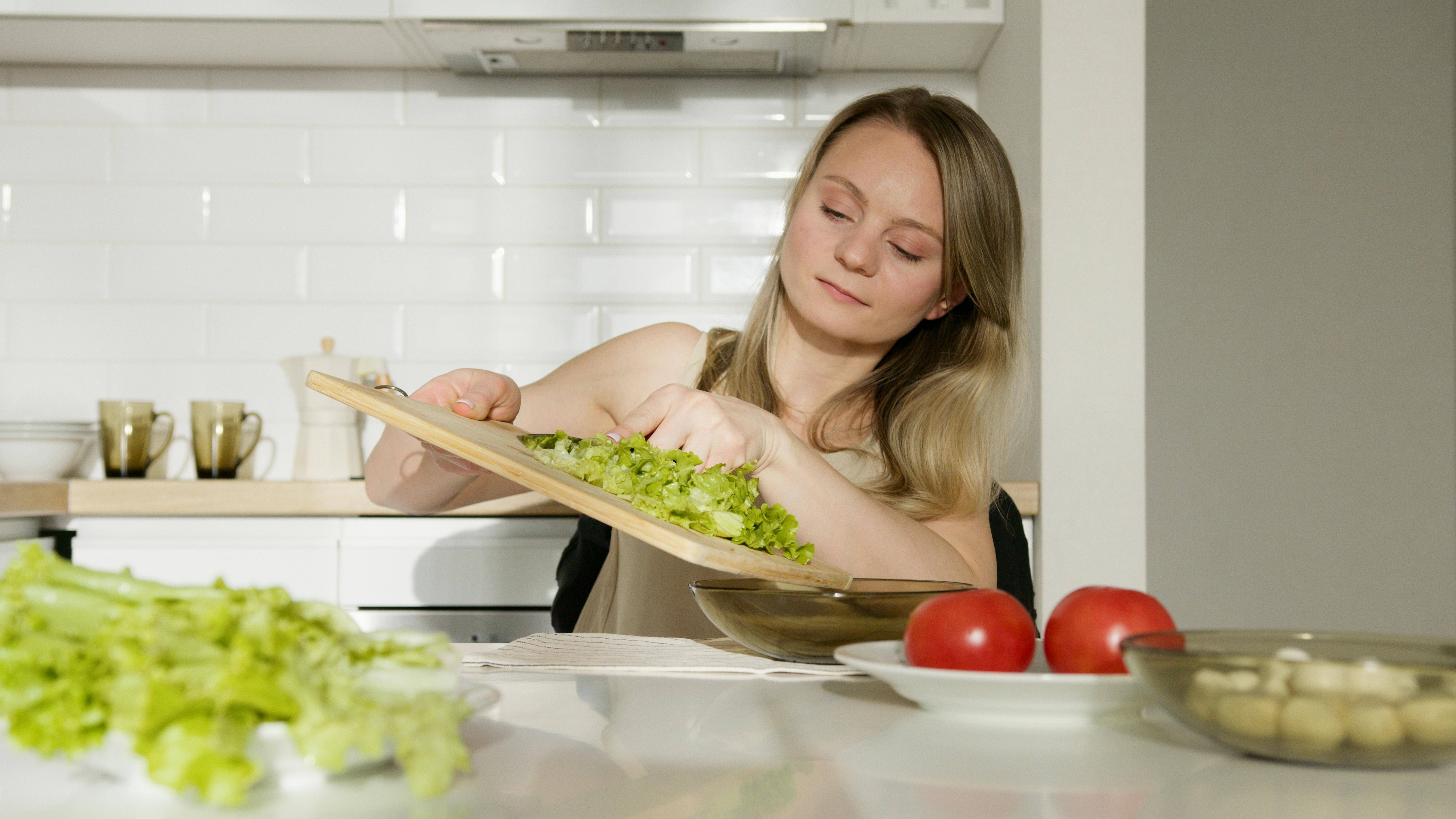 Junge Frau beim Salatmachen | Quelle: Pexels