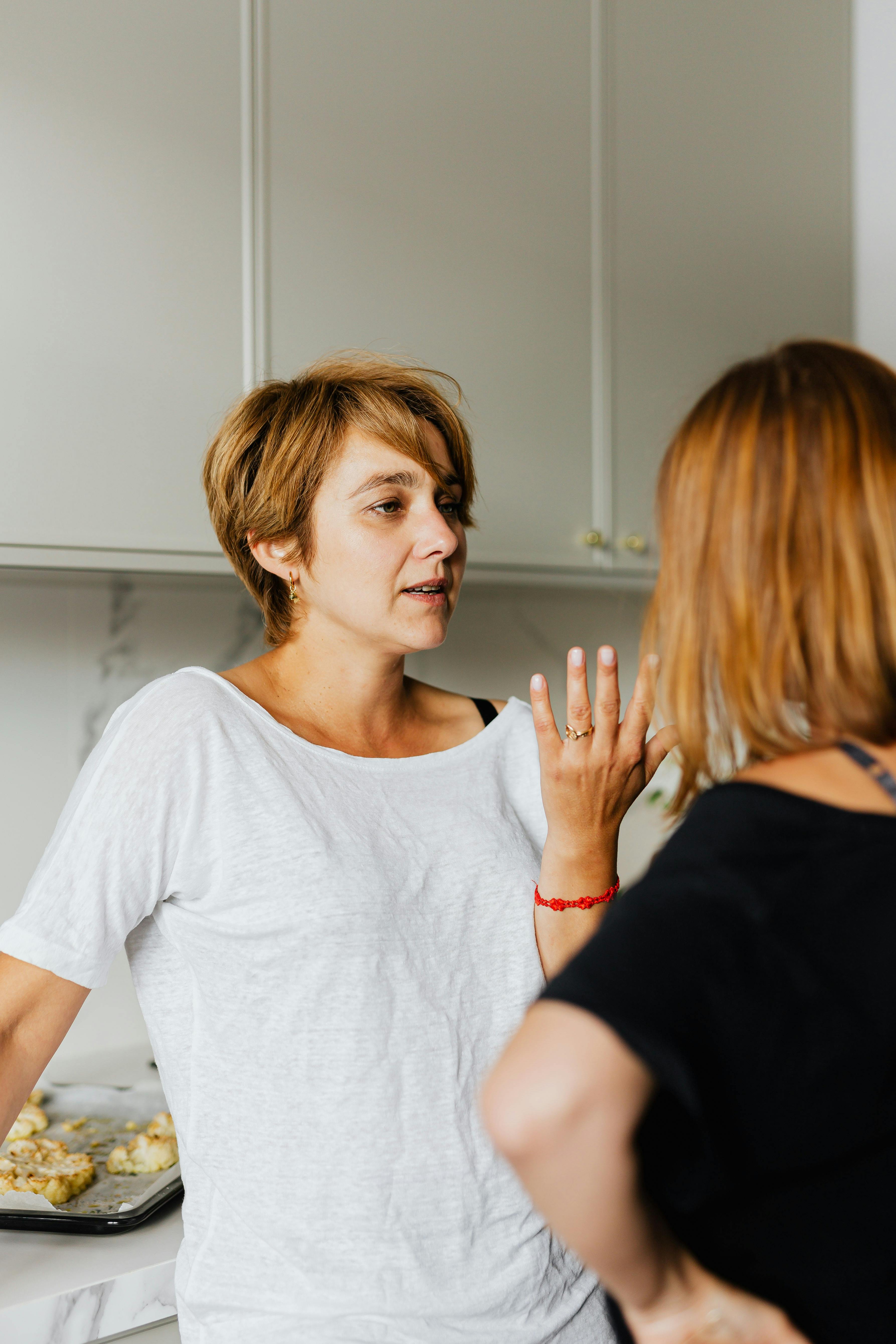 Zwei Frauen unterhalten sich in der Küche | Quelle: Pexels