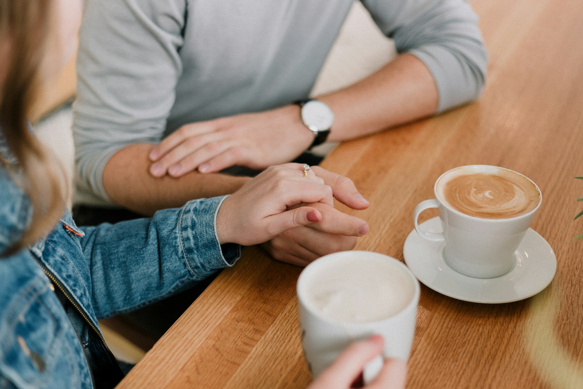 Graustufenaufnahme einer Frau, die die Hand eines Mannes hält | Quelle: Unsplash