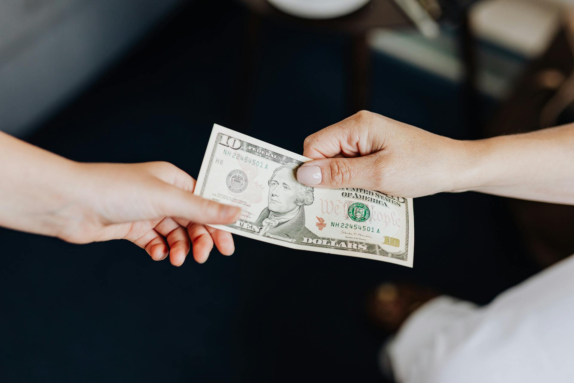 Eine Person, die einer anderen Person Geld überreicht | Quelle: Pexels