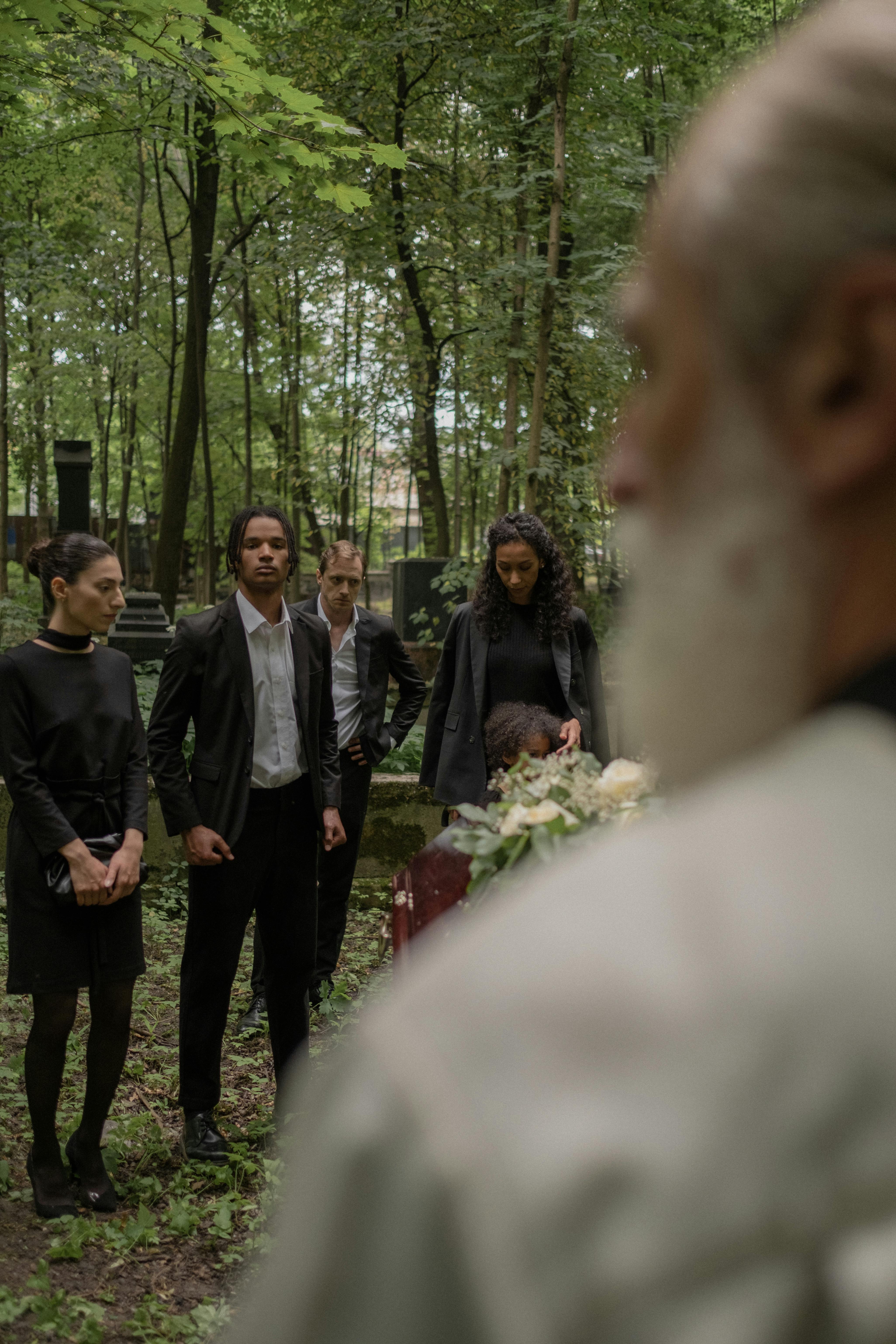 Menschen, die auf einem Friedhof stehen | Quelle: Pexels