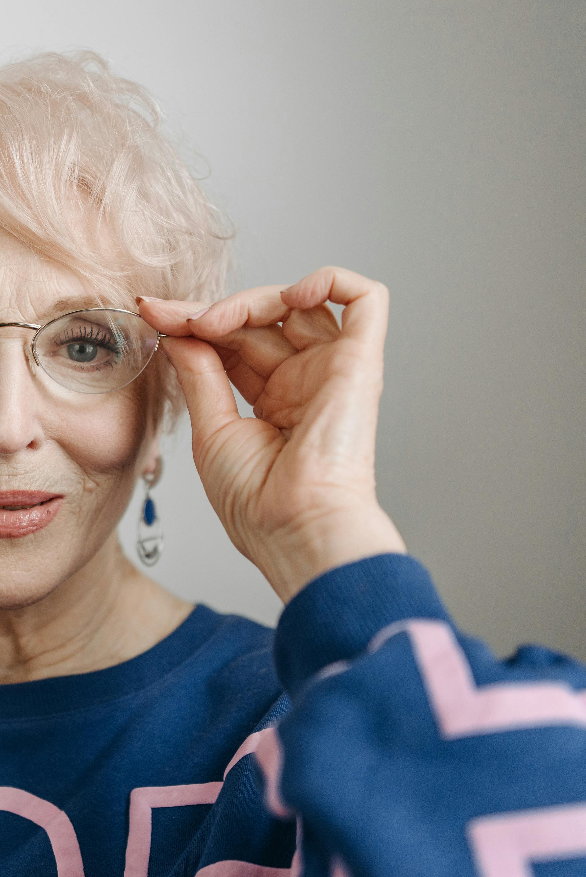 Eine Nahaufnahme einer älteren Frau, die ihre Brille anfasst | Quelle: Pexels