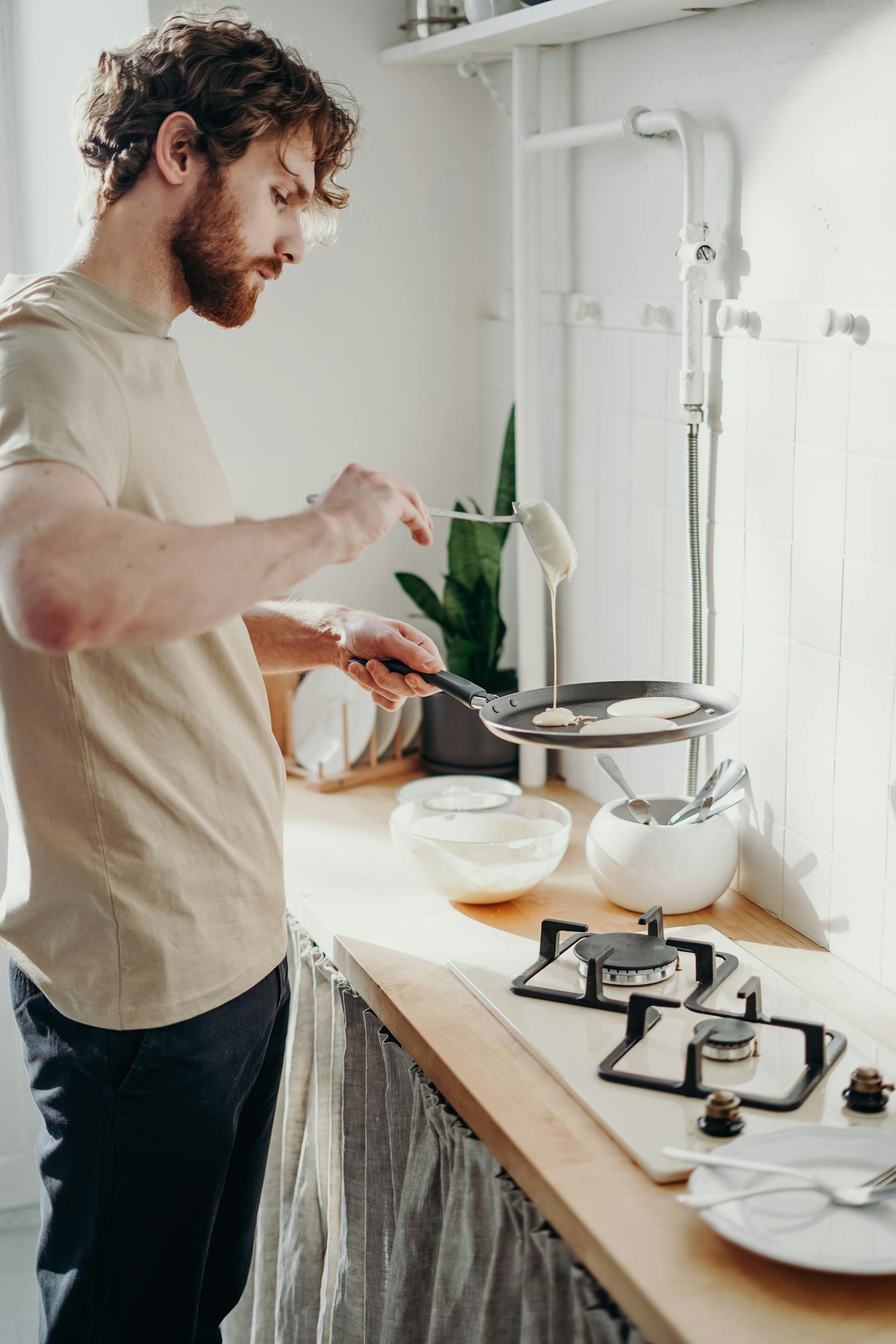 Ein Mann macht Pfannkuchen in der Küche | Quelle: Pexels