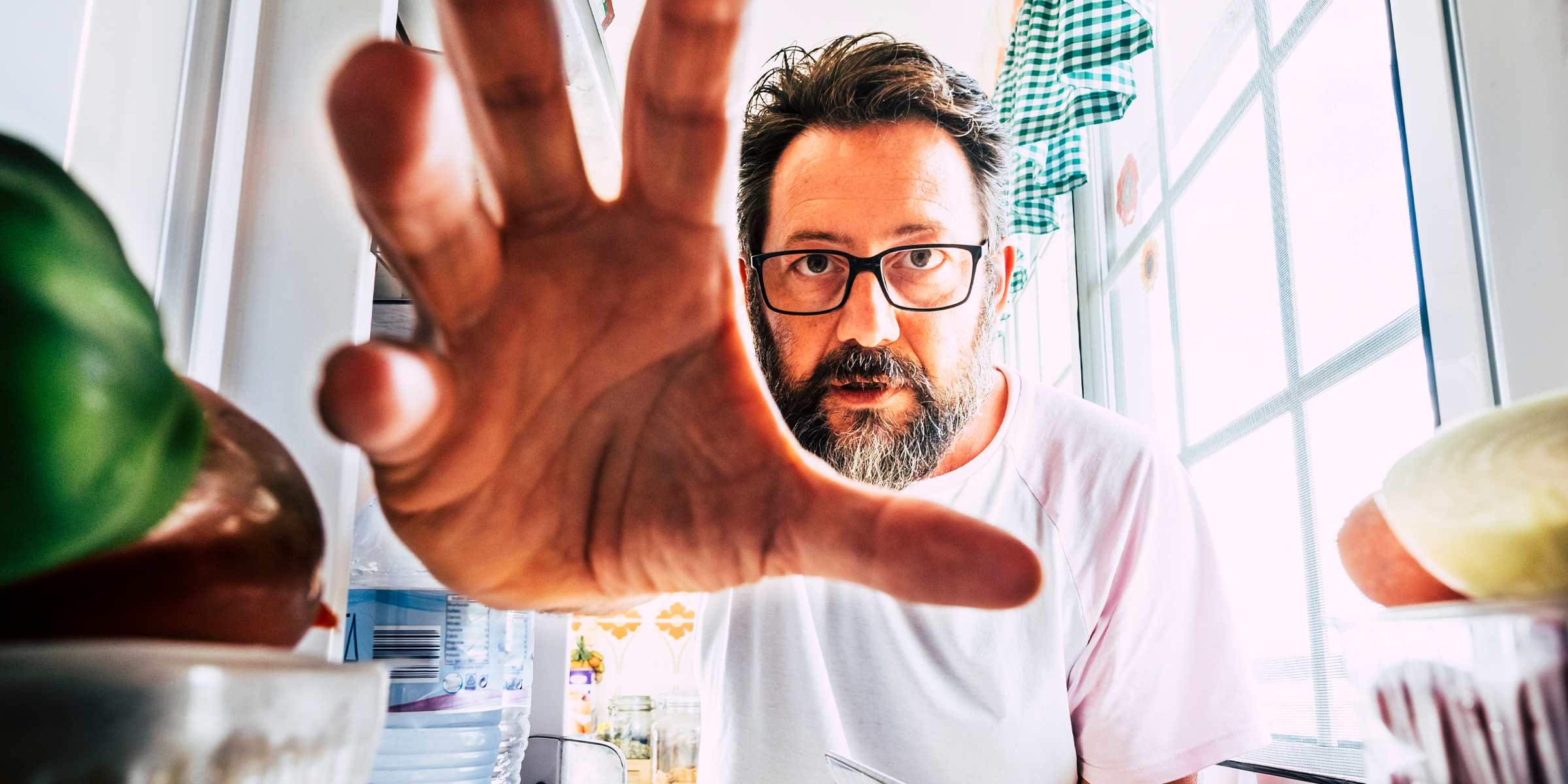 Mann holt Essen aus dem Kühlschrank | Quelle: Shutterstock