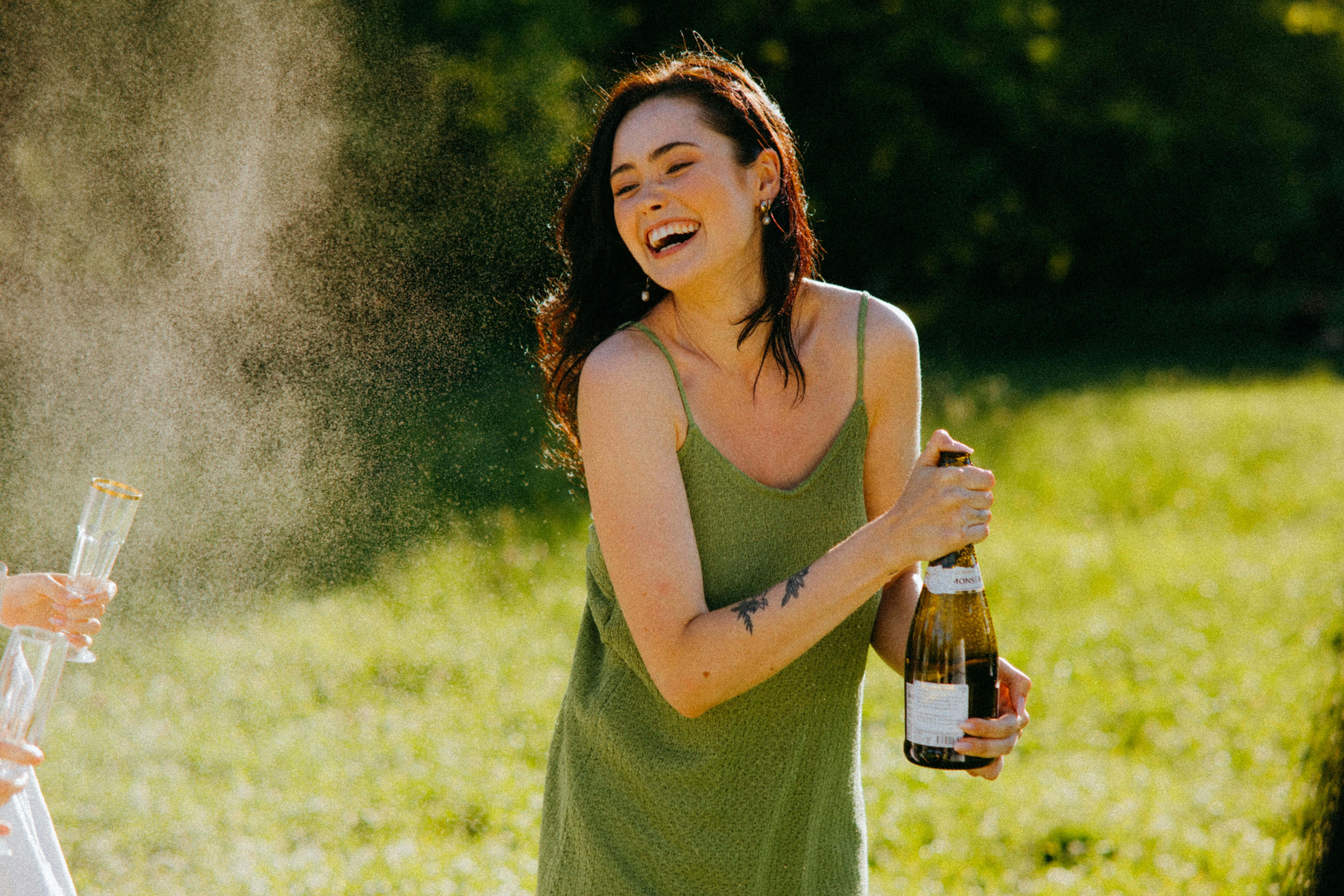 Eine lachende Frau, die eine Flasche in der Hand hält | Quelle: Pexels