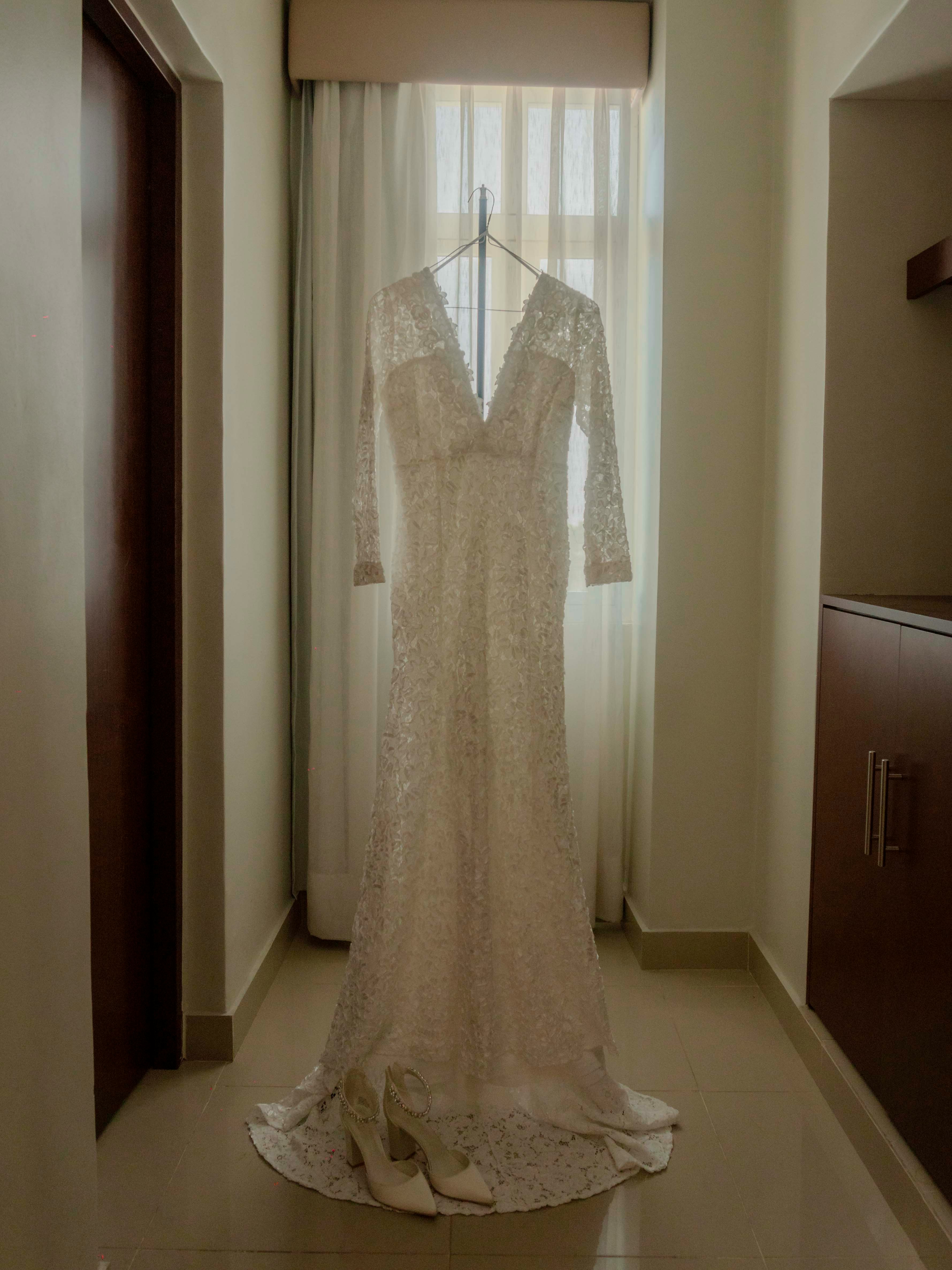Hochzeitskleid vor einem Fenster hängend | Quelle: Unsplash