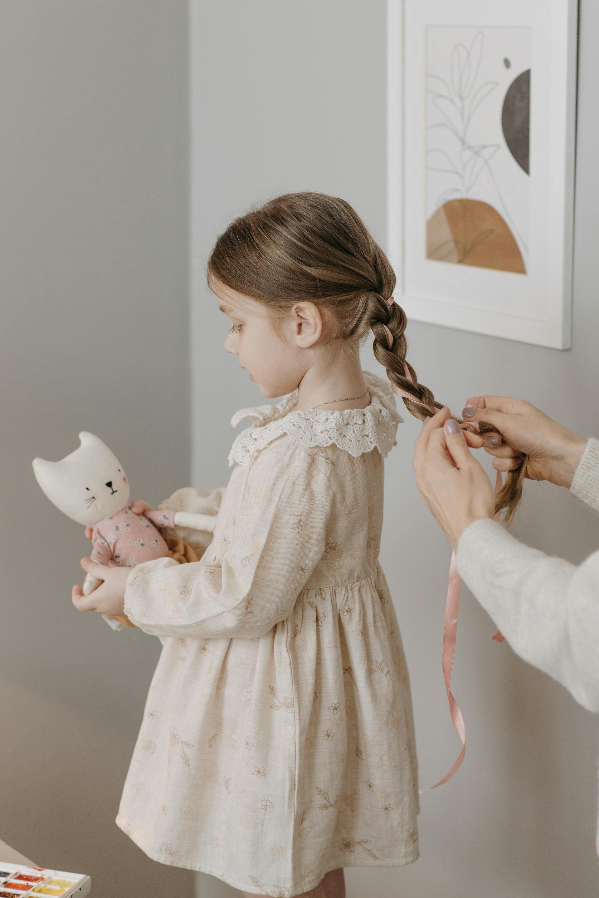 Eine Frau flechtet die Haare ihrer Tochter | Quelle: Pexels