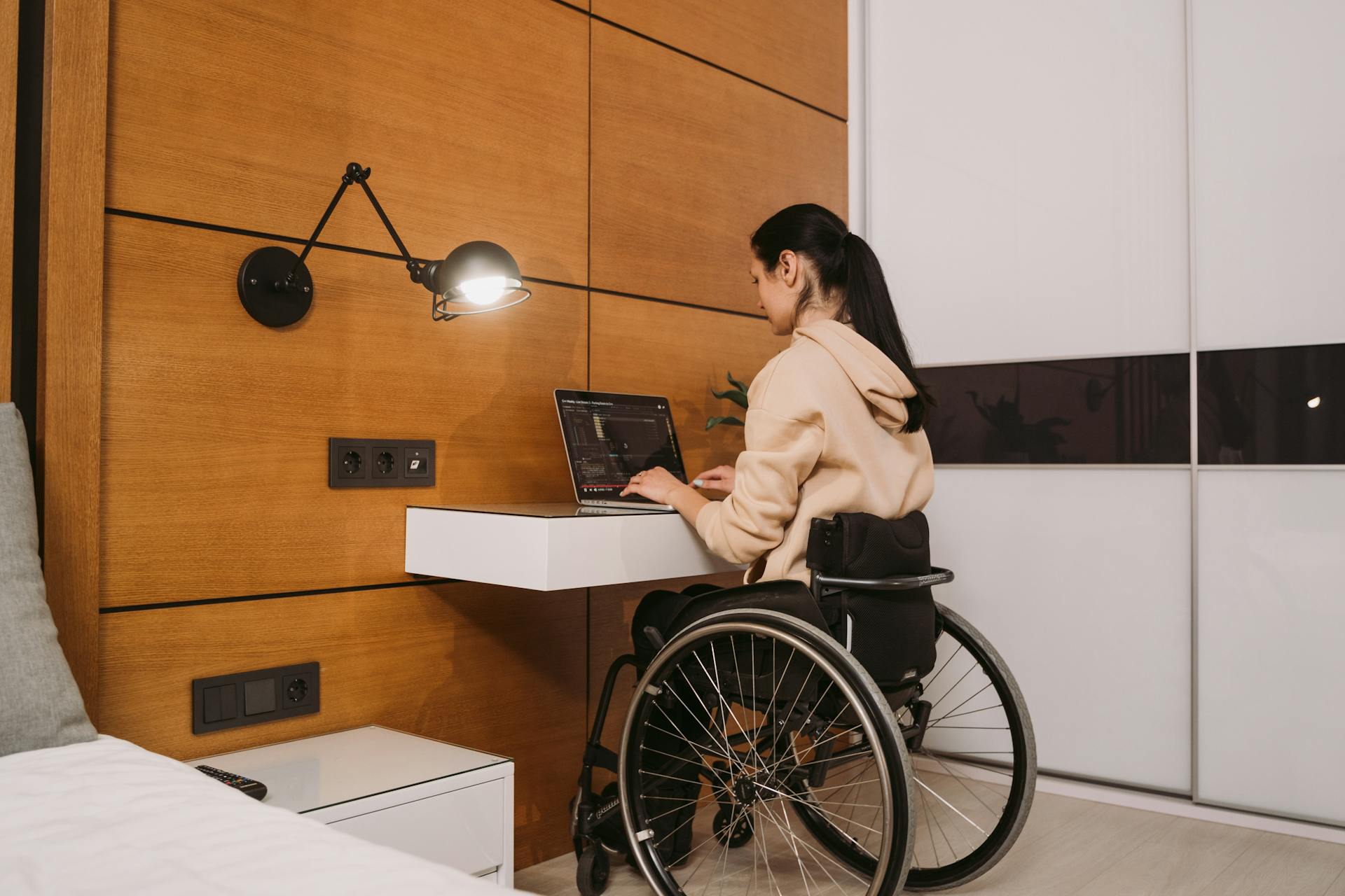 Eine Frau sitzt in ihrem Rollstuhl und benutzt ihren Laptop | Quelle: Pexels