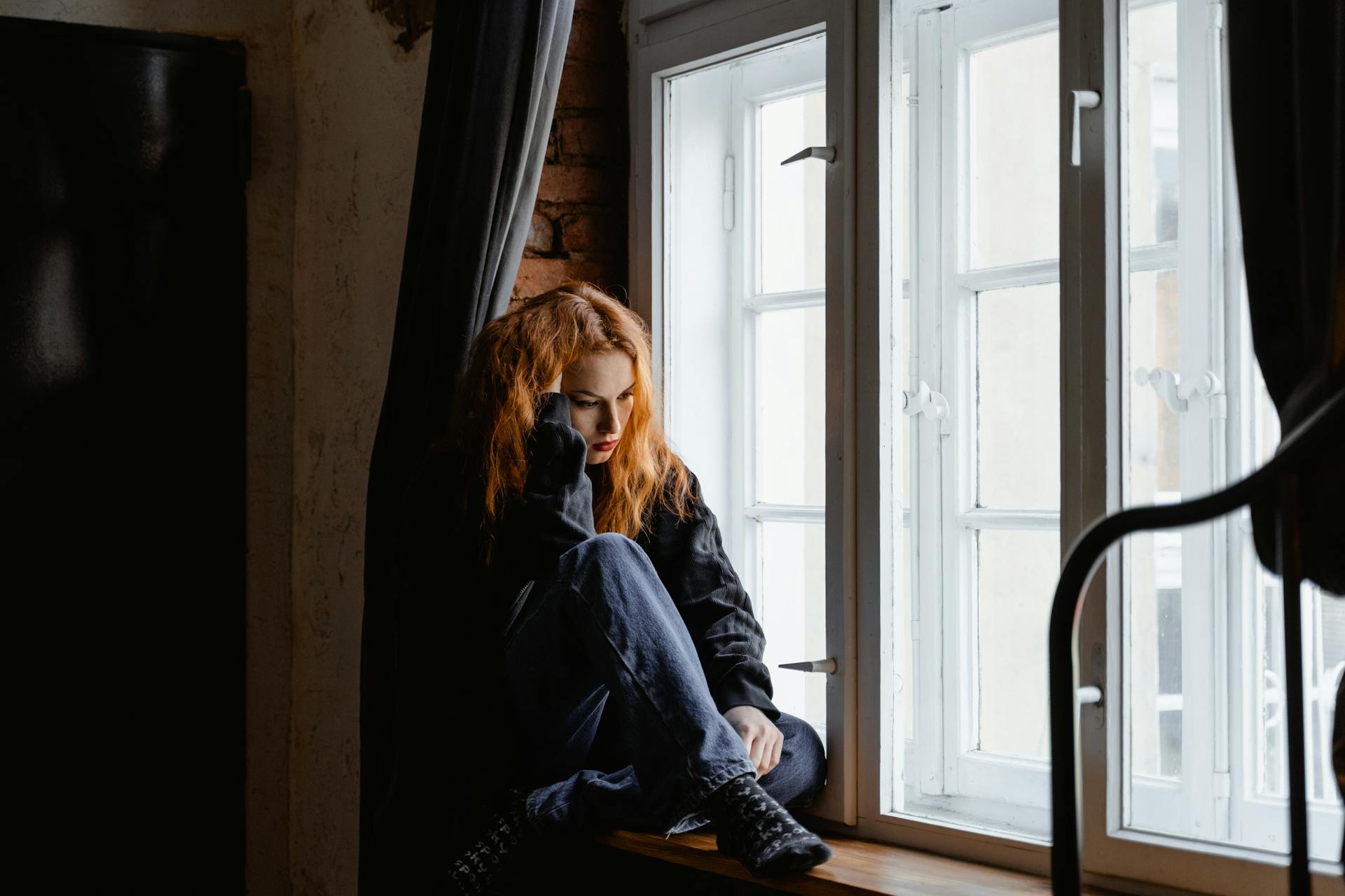 Eine Frau, die an einem Fenster sitzt | Quelle: Pexels