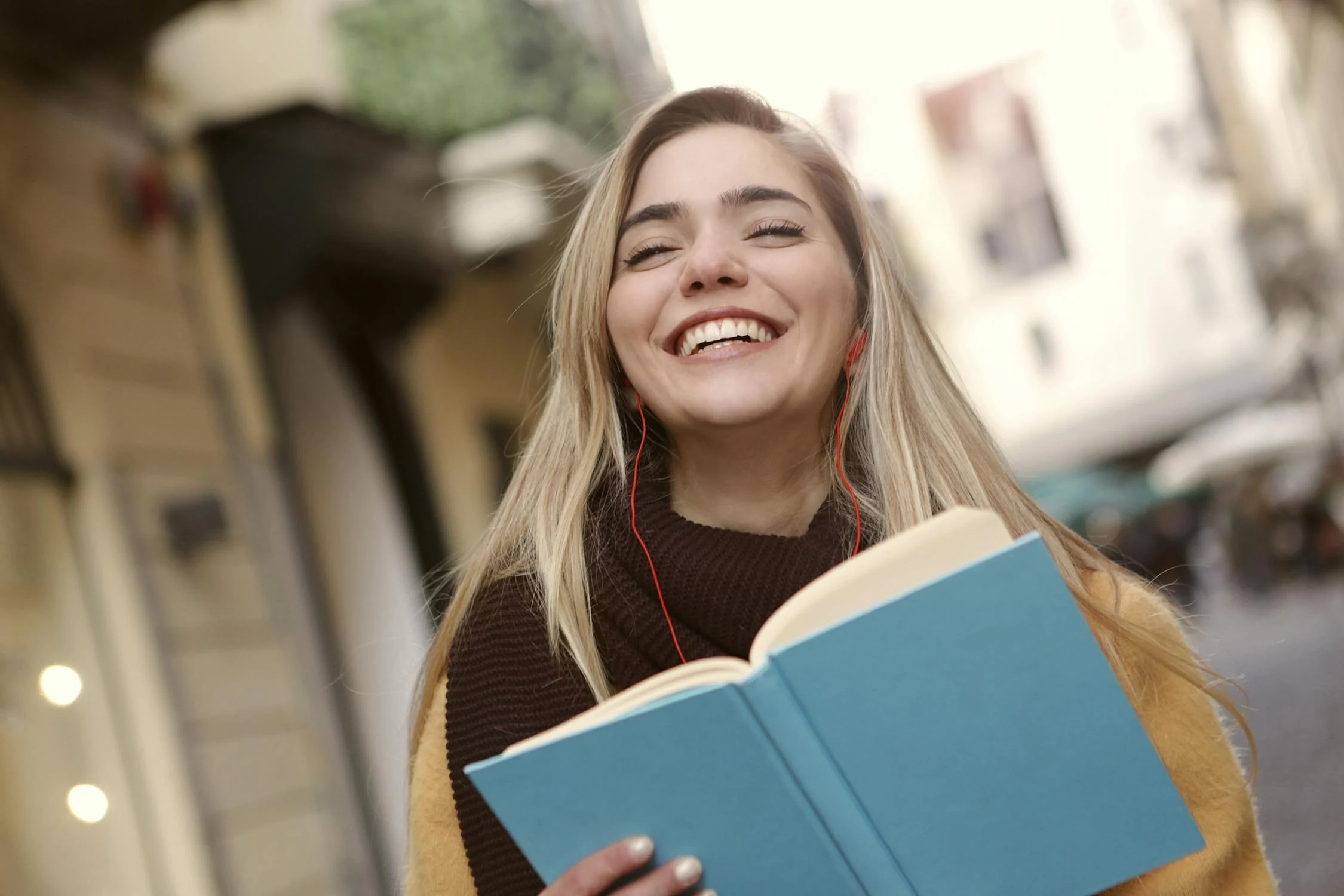 Eine lächelnde Frau mit einem Buch | Quelle: Pexels