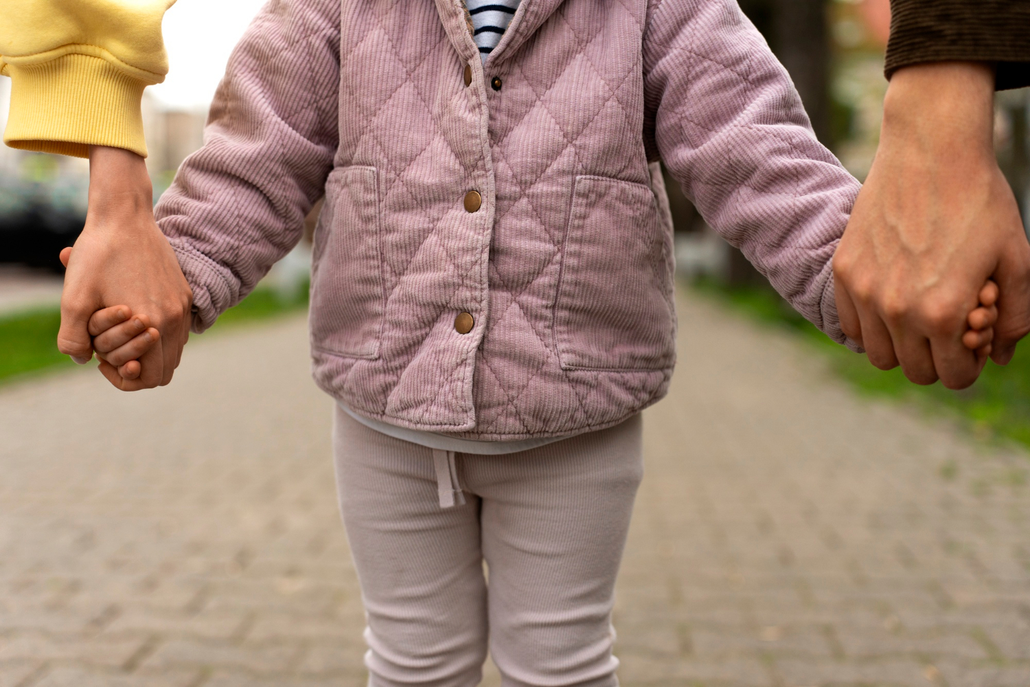 Ein Kind hält die Hand seiner Eltern | Quelle: Freepik