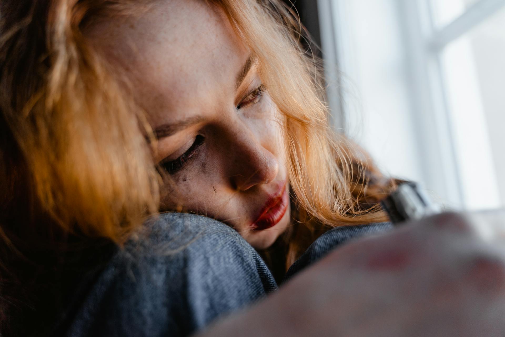 Eine traurige Frau, die aus einem Fenster starrt | Quelle: Pexels