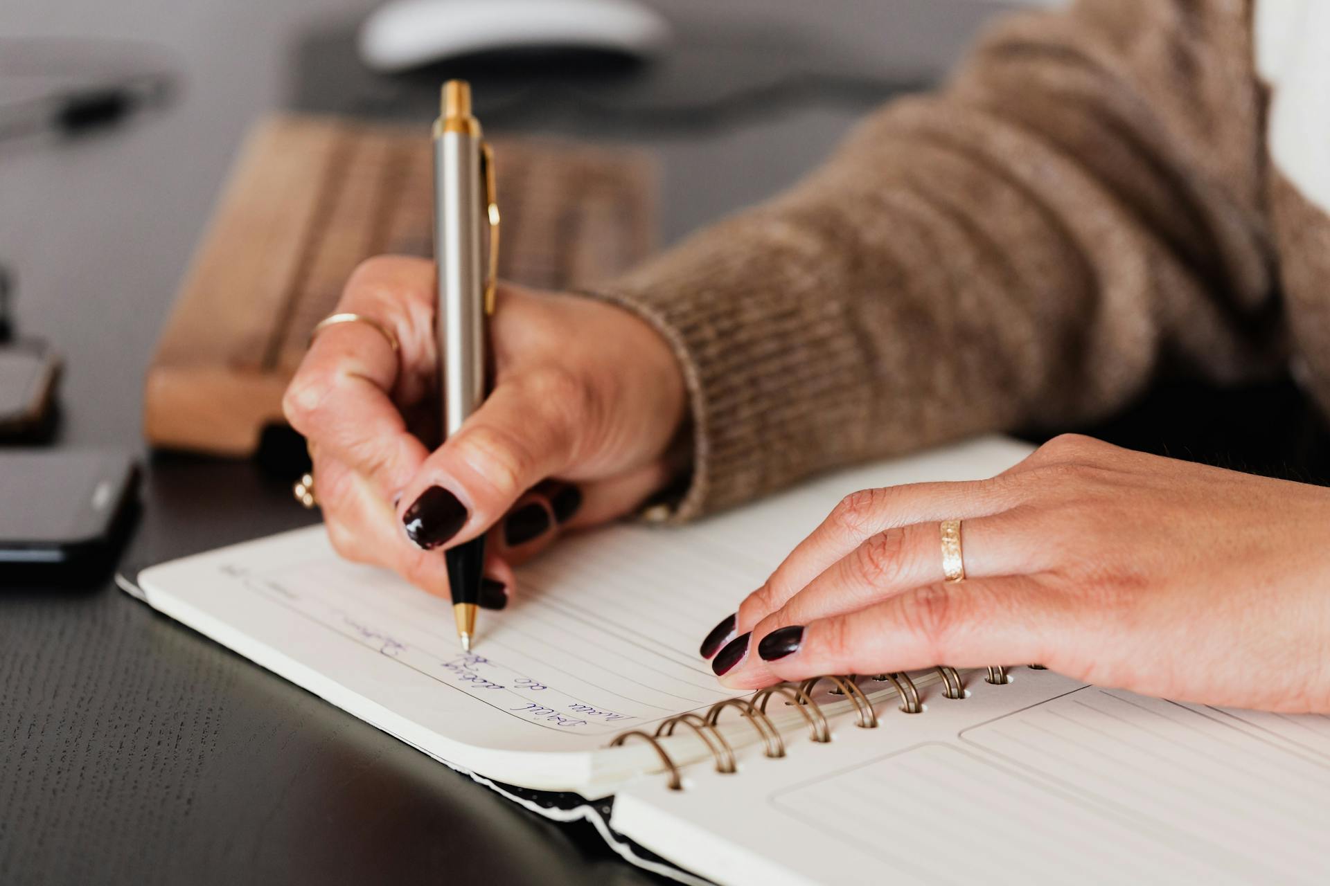 Eine Frau, die in ein Notizbuch schreibt | Quelle: Pexels