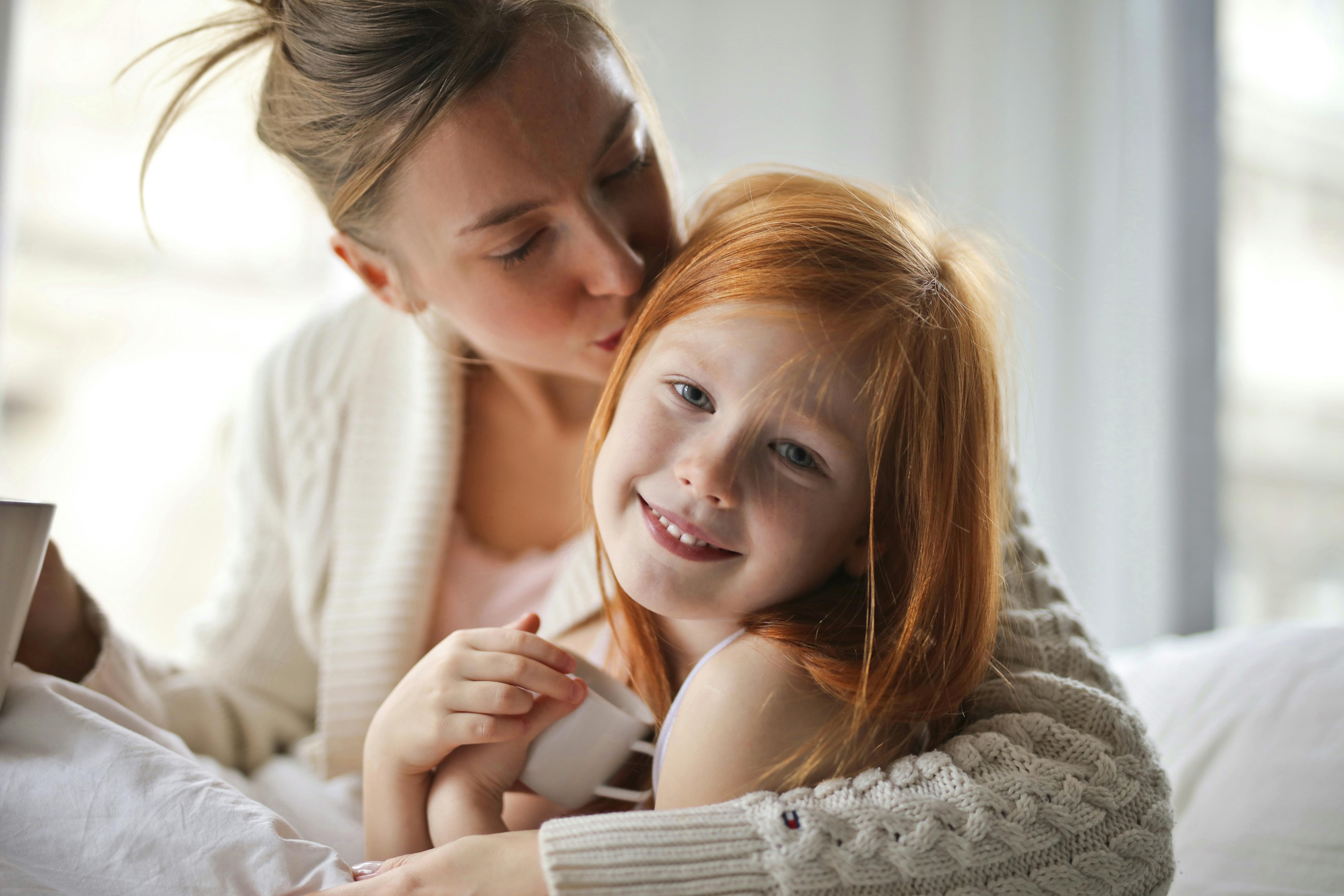 Eine Mutter küsst den Kopf ihres Kindes | Quelle: Pexels