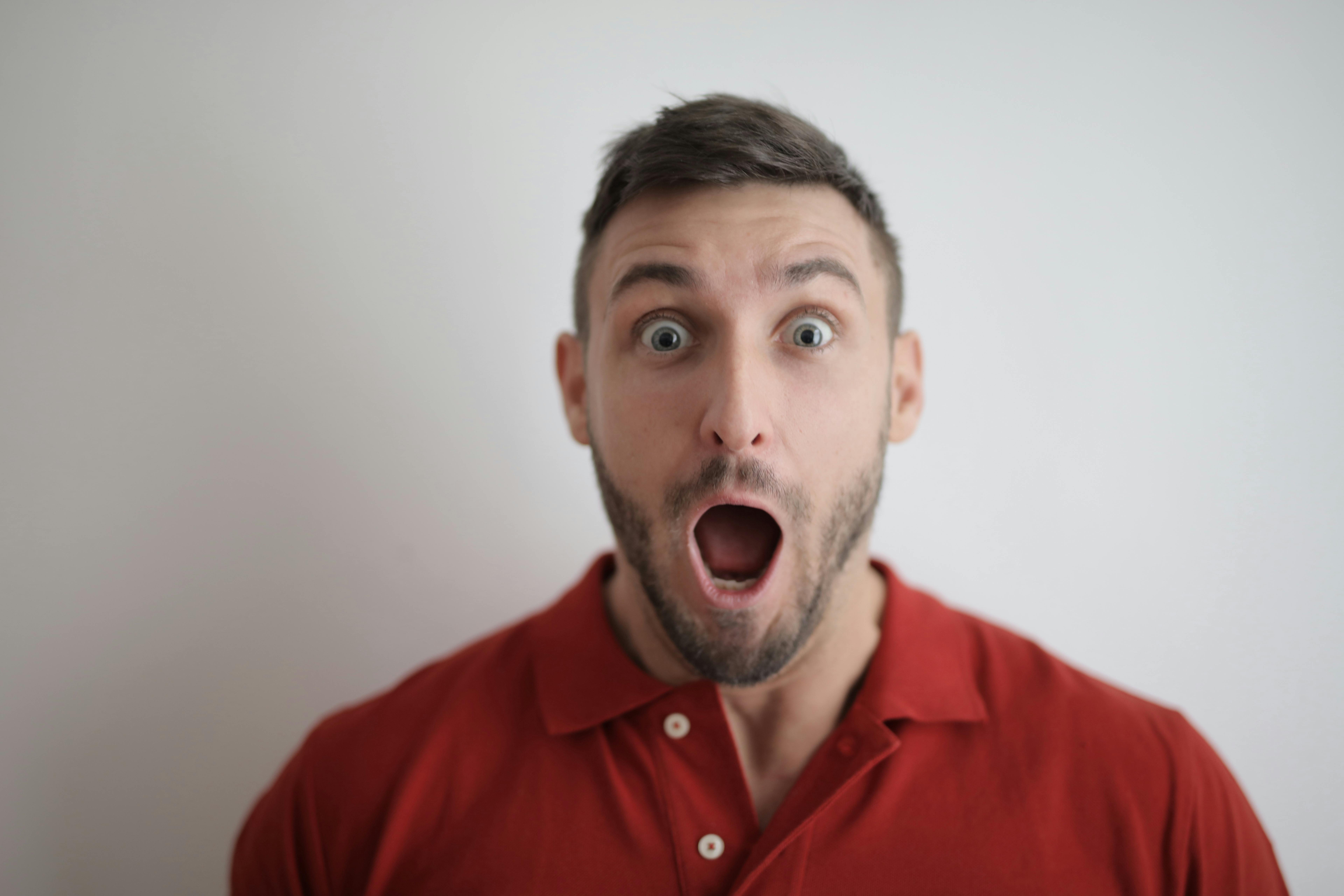 Ein schockierter Mann in einem roten Hemd | Quelle: Pexels