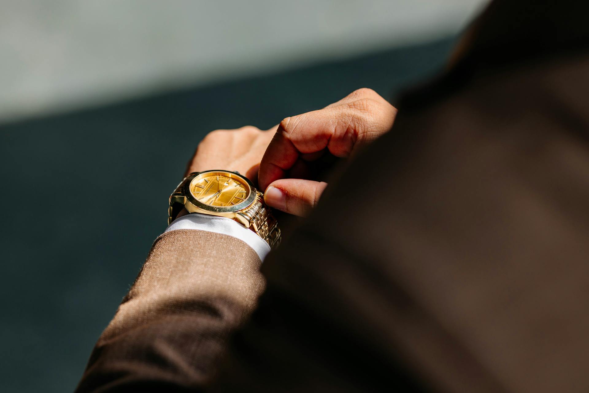 Eine Nahaufnahme eines Mannes im Anzug, der seine Armbanduhr berührt | Quelle: Pexels