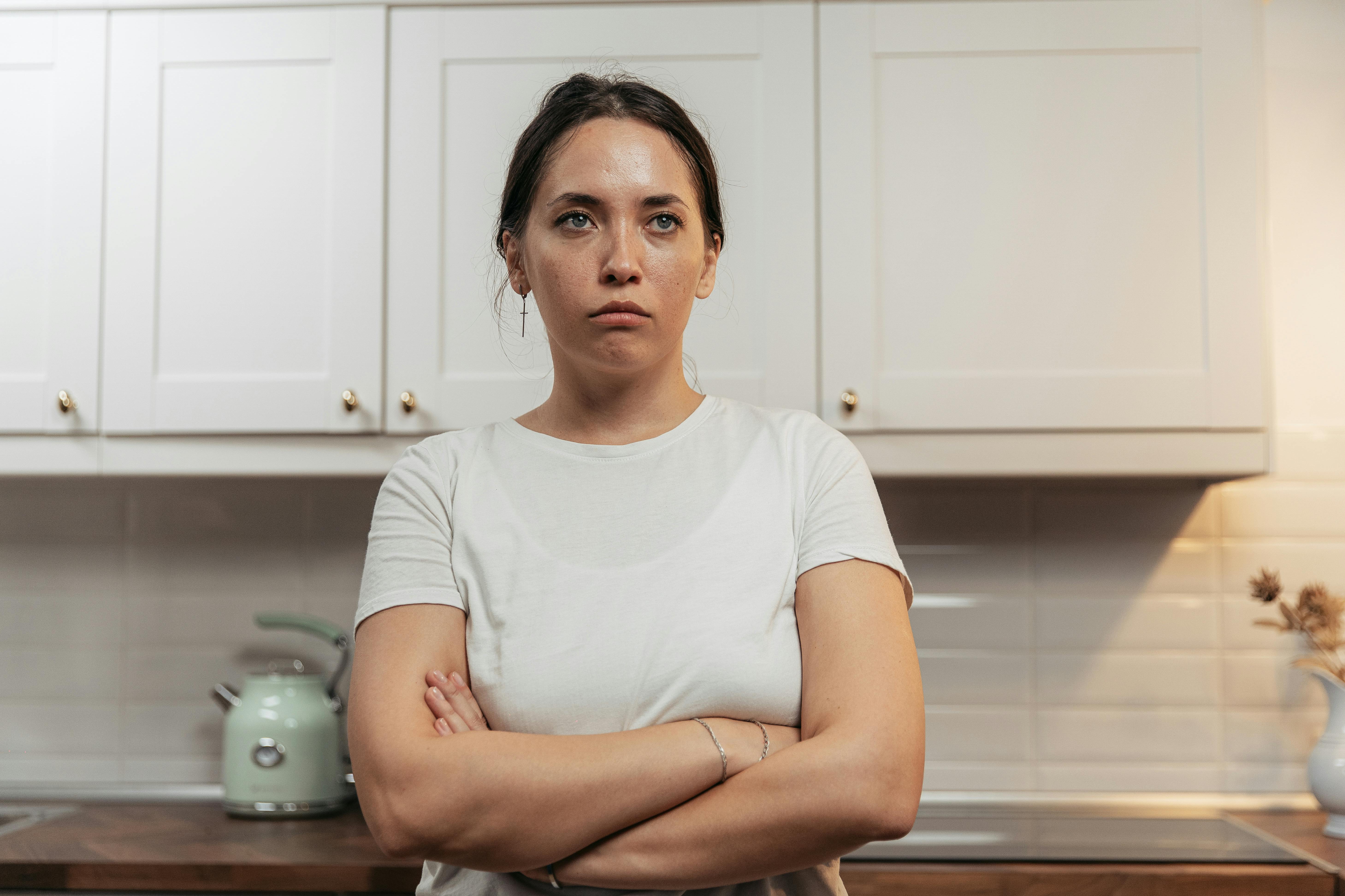 Eine aufgebrachte Frau, die mit verschränkten Armen dasteht | Quelle: Pexels