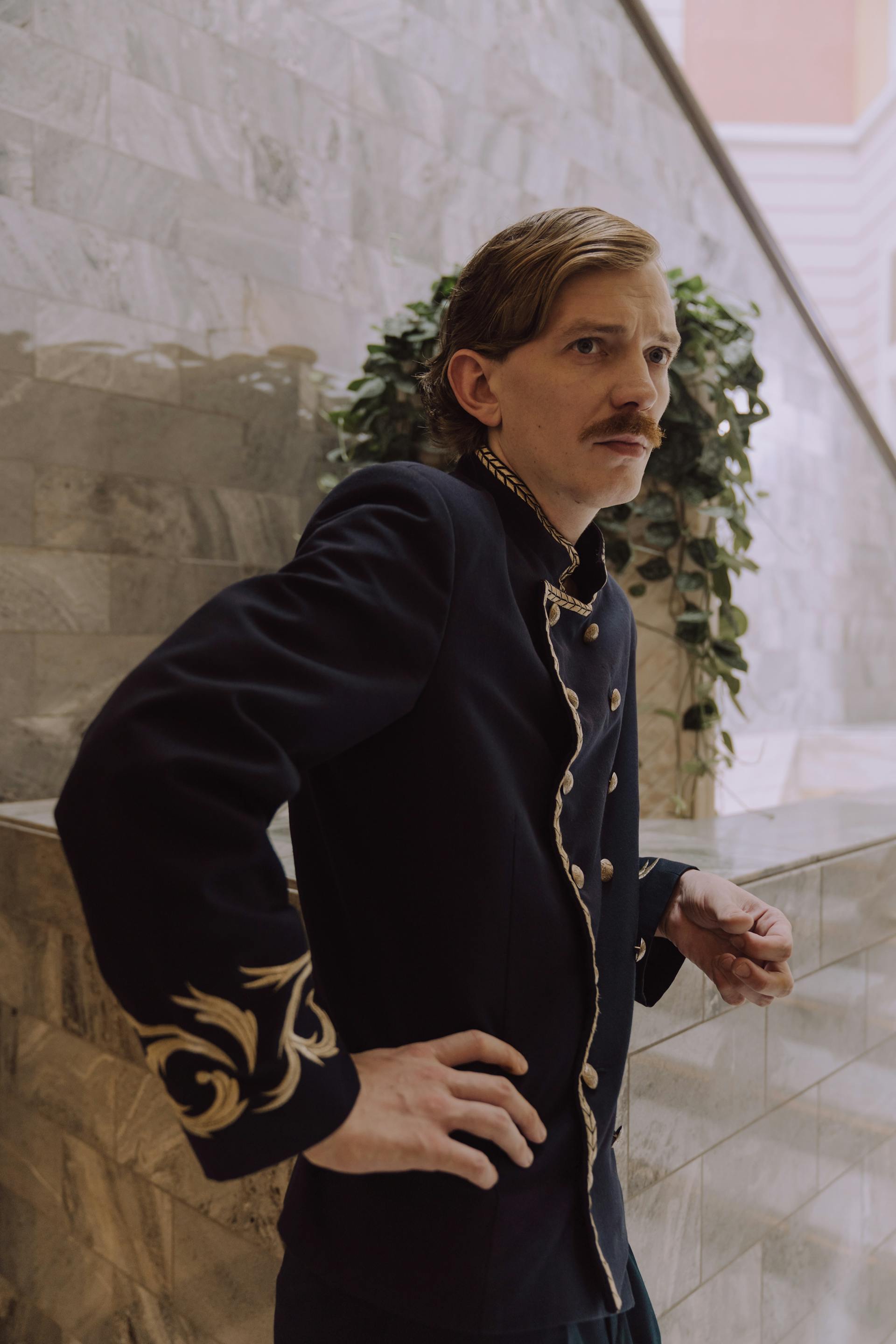 Ein Mann in einer Hotelconcierge-Uniform mit ernster Miene | Quelle: Pexels