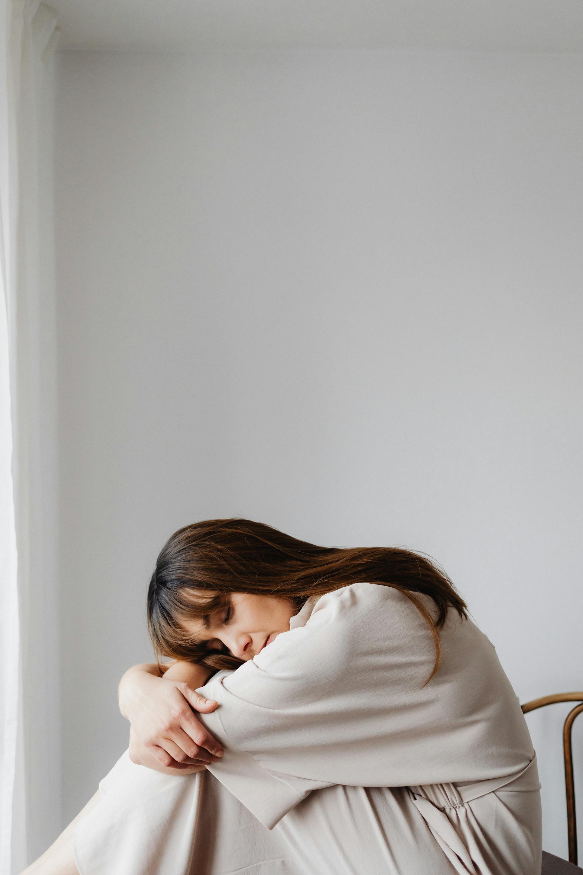 Eine müde Frau, die in einer gebeugten Haltung sitzt | Quelle: Pexels