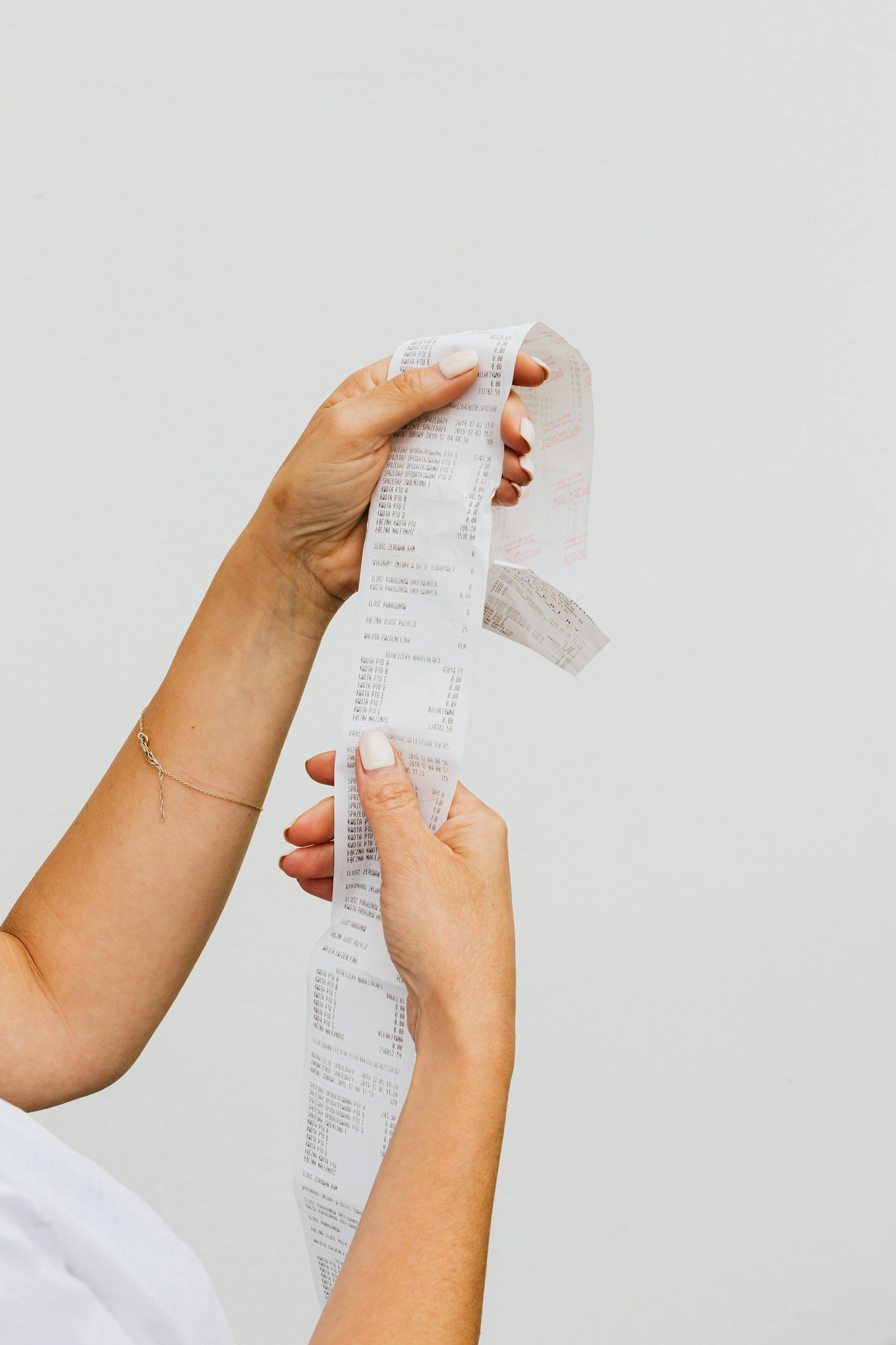 Eine Person, die eine Quittung hält | Quelle: Pexels
