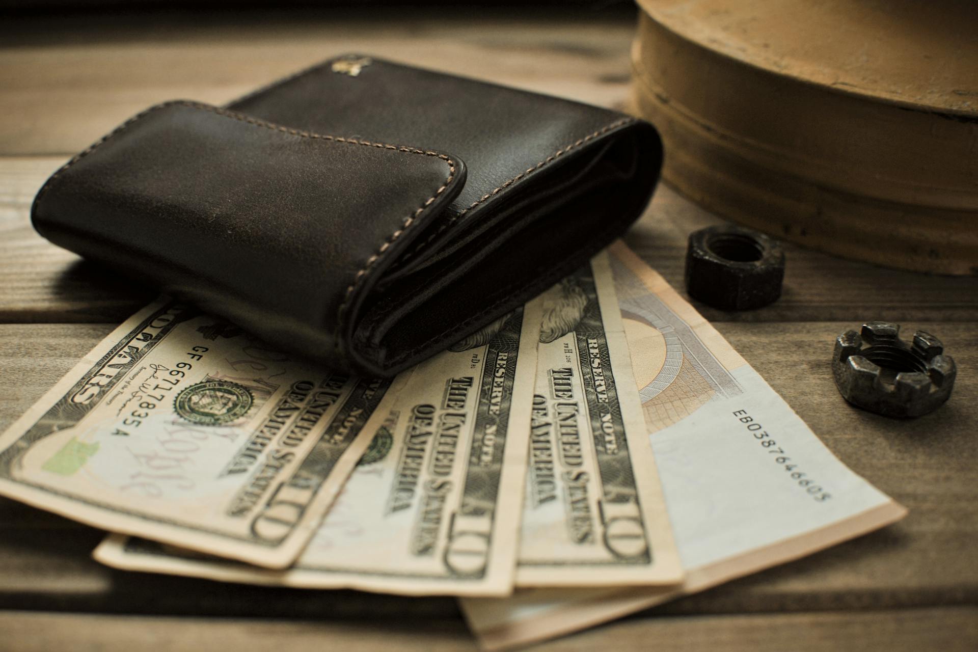 Ein Portemonnaie auf einem Haufen Dollarscheine | Quelle: Pexels