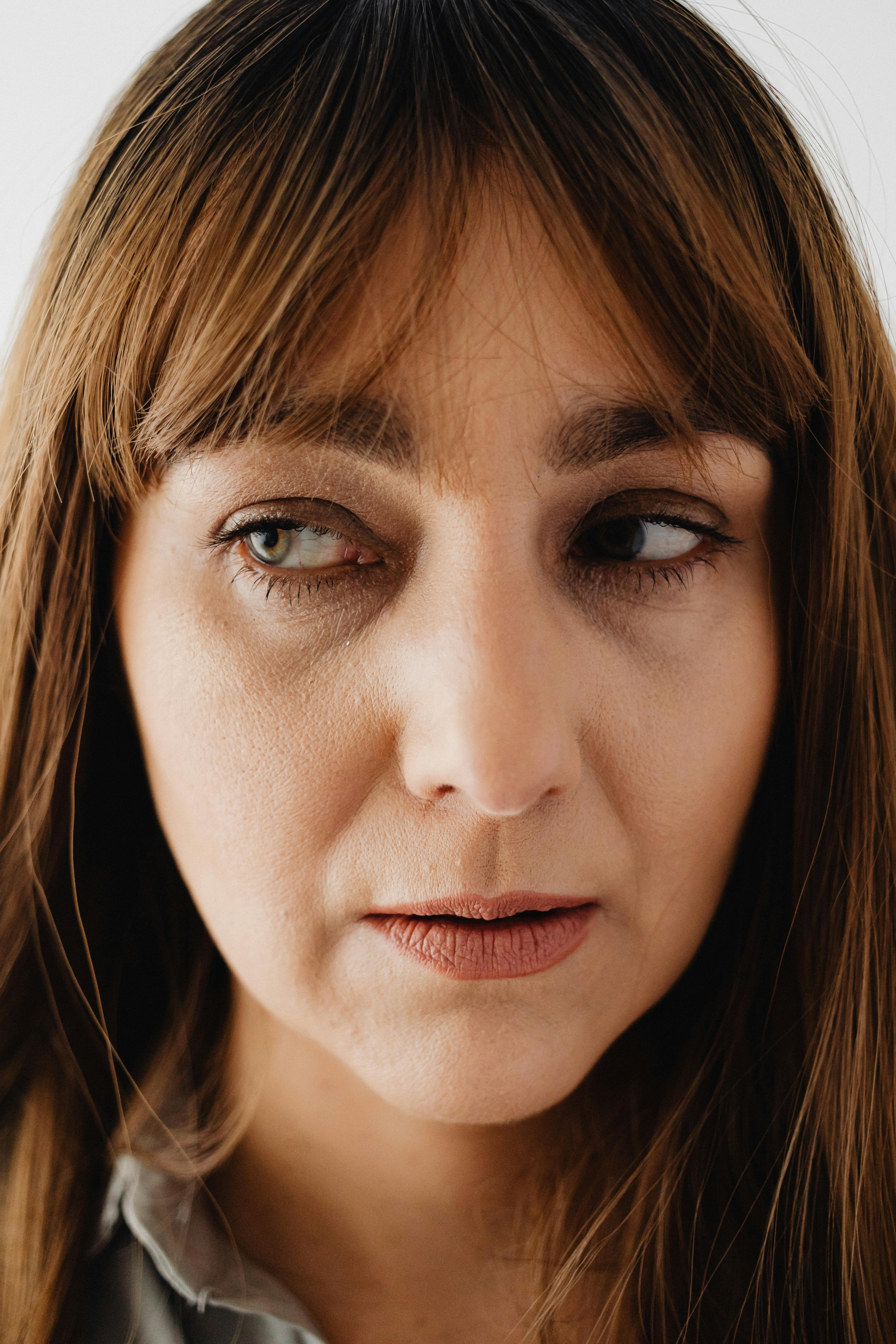 Eine unglückliche Frau, die zur Seite schaut | Quelle: Pexels