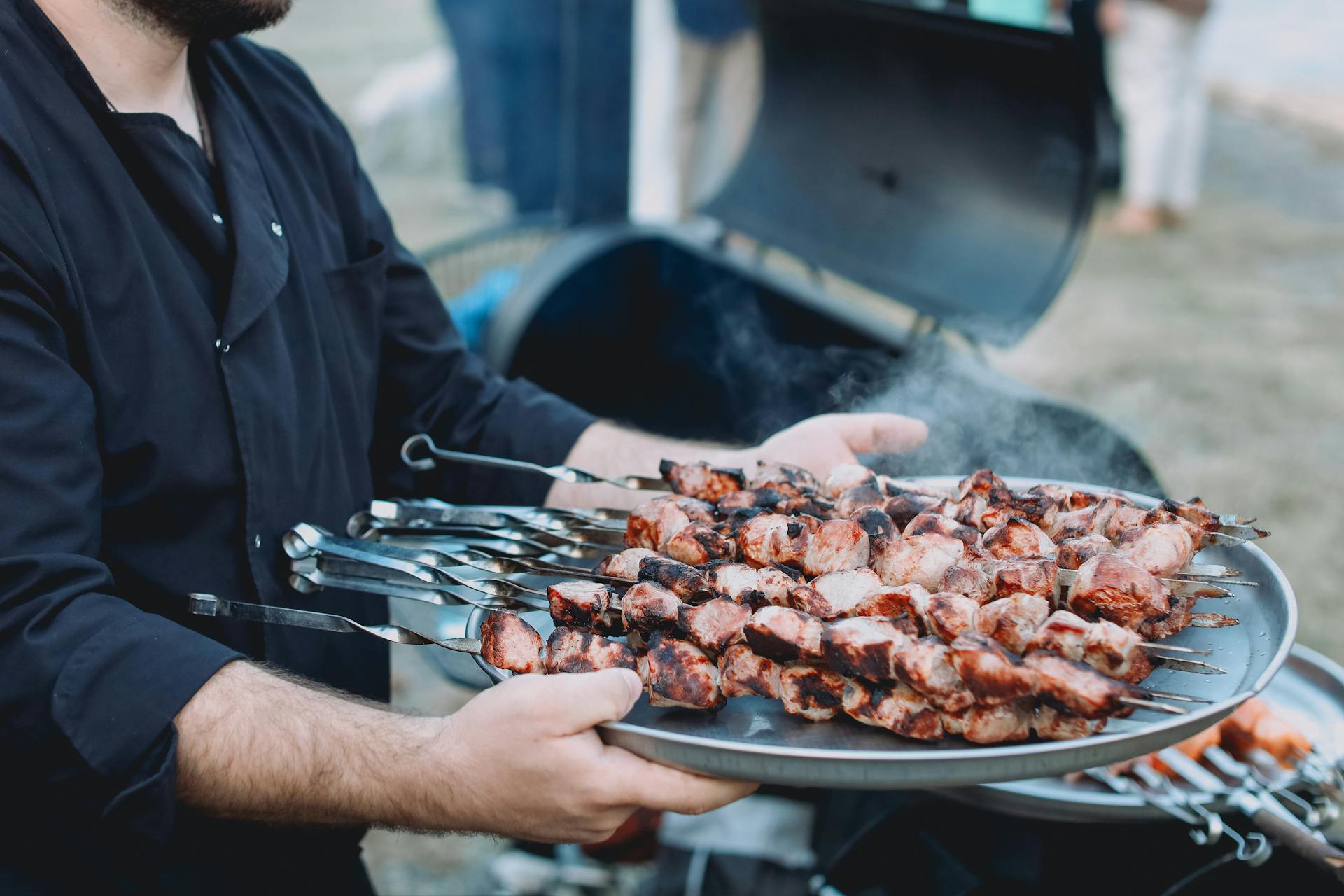 Ein Mann hält ein Tablett mit Fleisch | Quelle: Pexels
