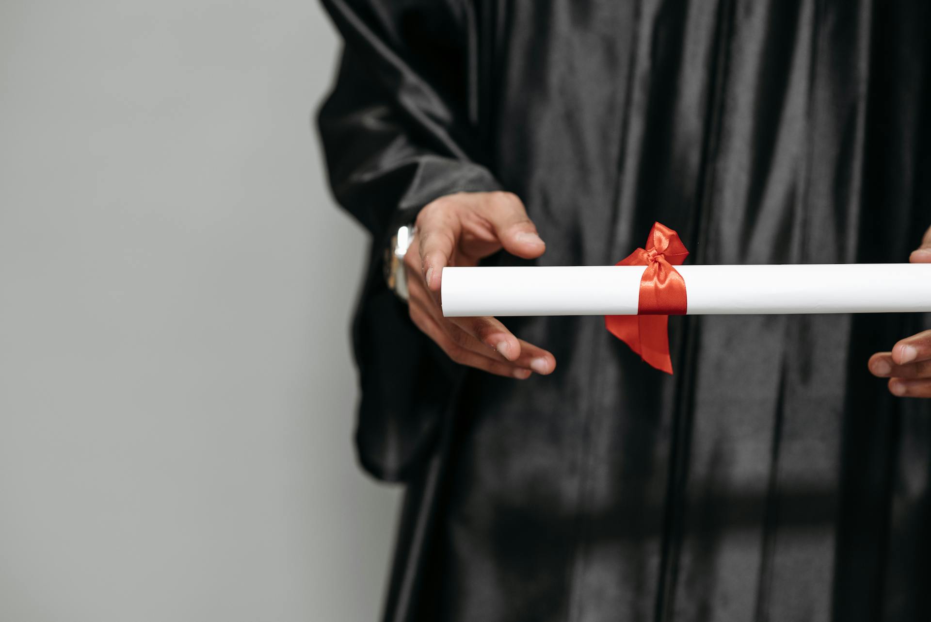 Eine Person hält ein Diplom in die Höhe | Quelle: Pexels