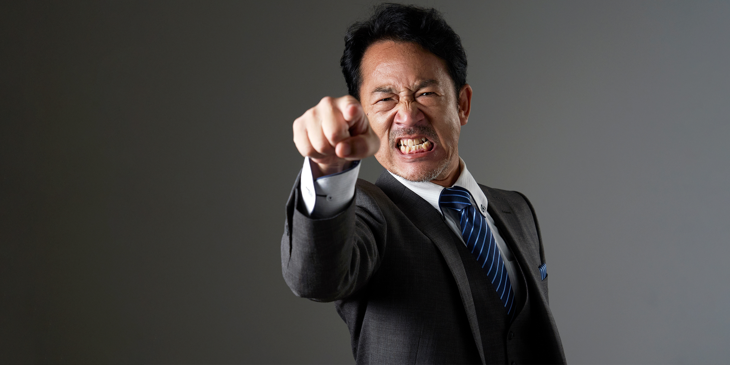 Ein wütender Mann, der auf jemanden zeigt | Shutterstock