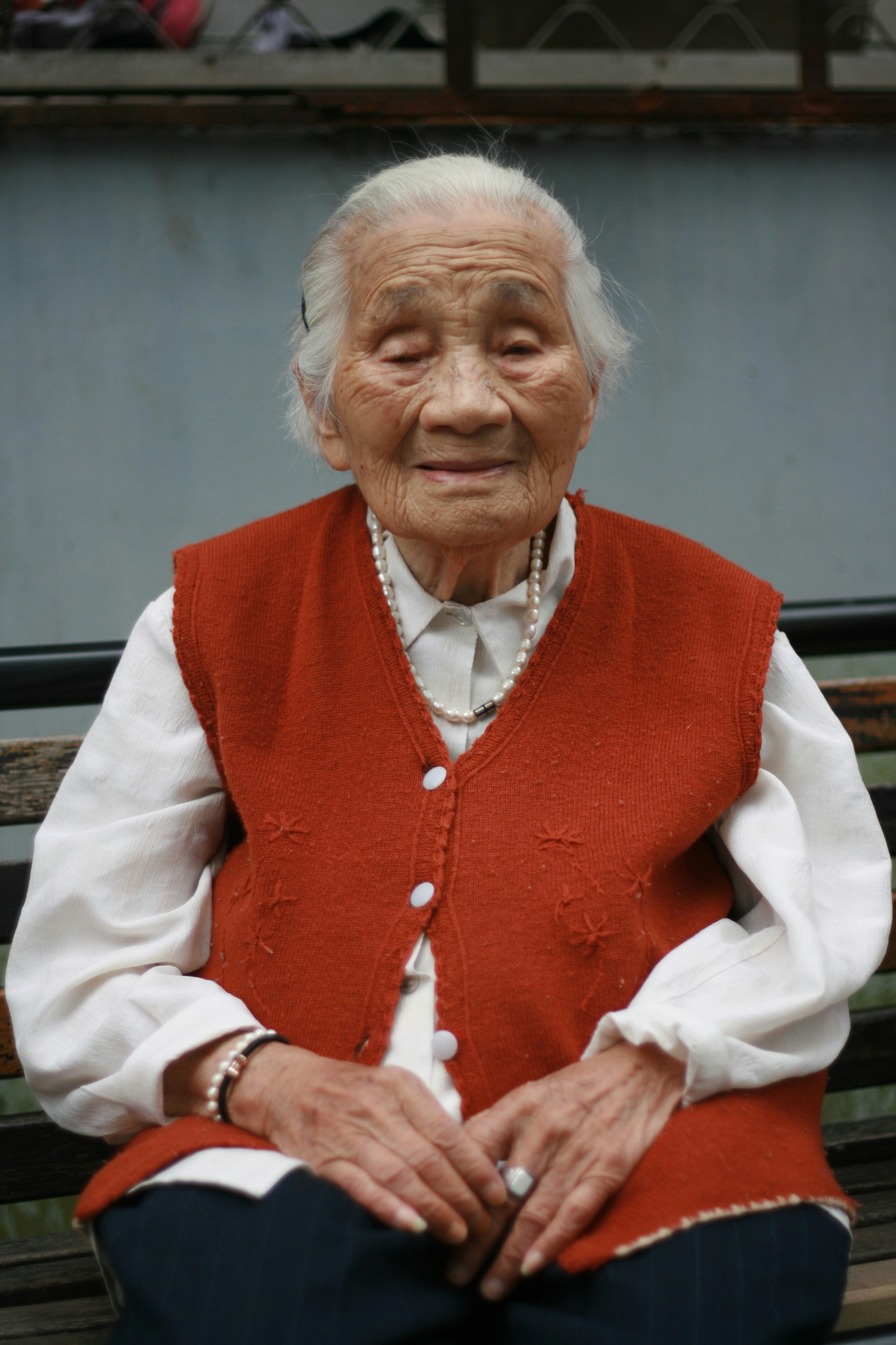 Eine alte Frau mit einer roten Weste | Quelle: Unsplash