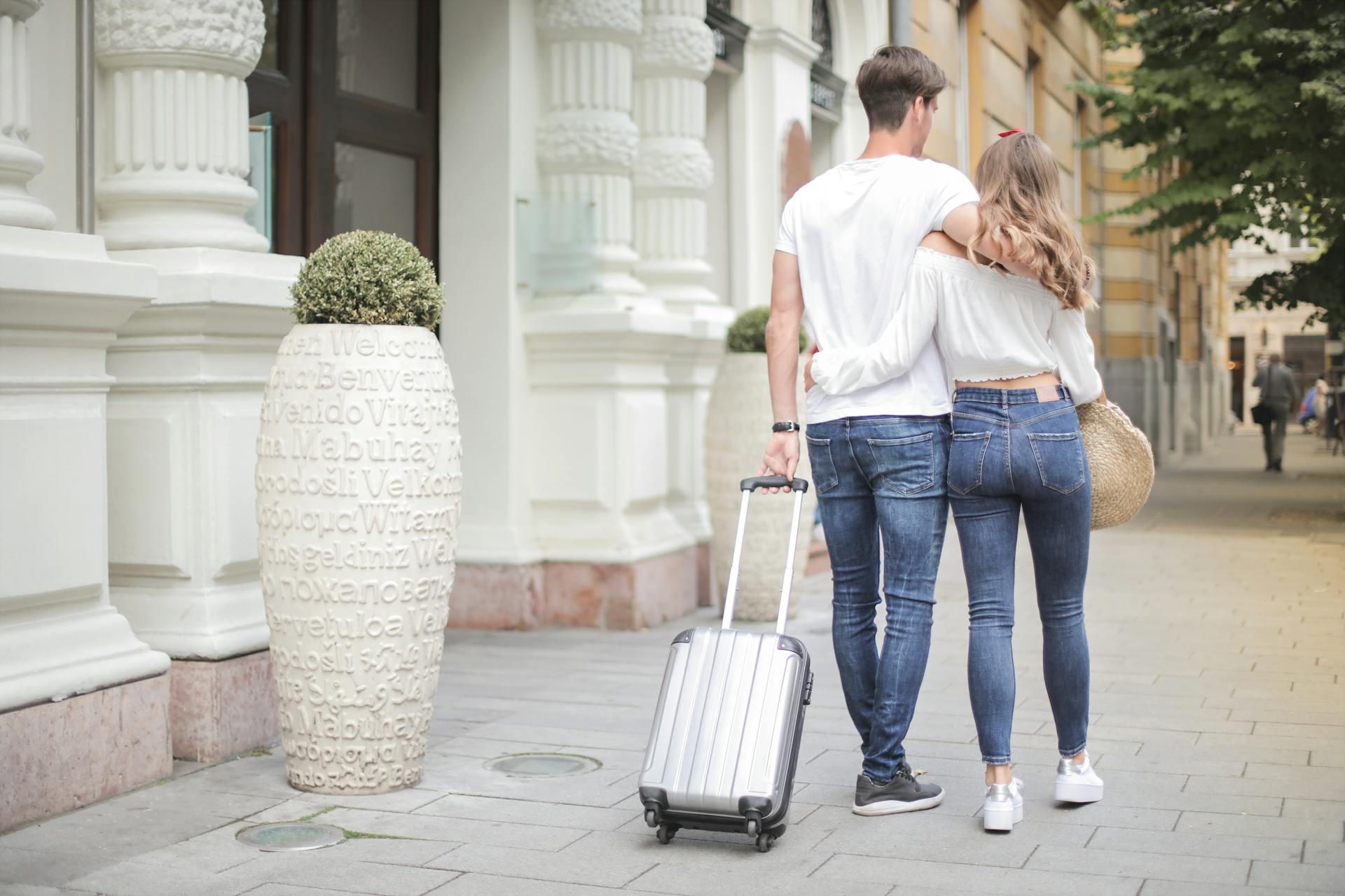 Ein Paar, das mit seinem Gepäck auf der Straße spazieren geht | Quelle: Pexels