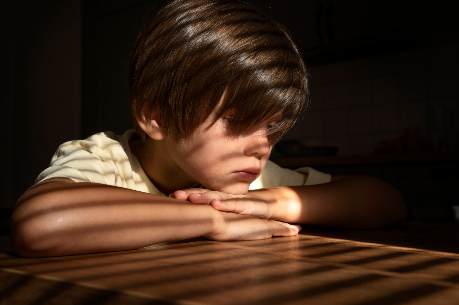 Ein trauriger Junge, der an einem Tisch sitzt | Quelle: Freepik