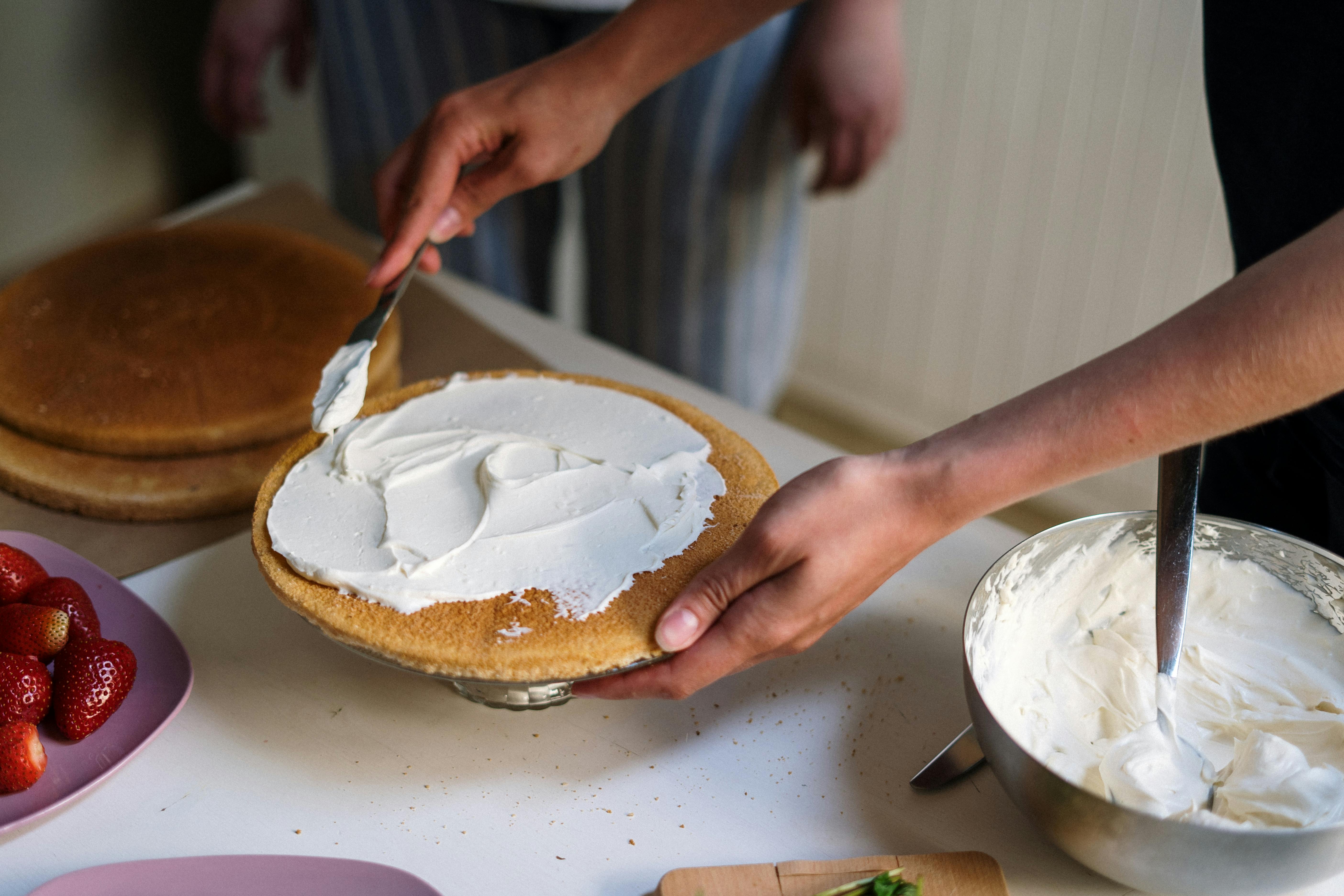 Eine Person, die einen Kuchen glasiert | Quelle: Pexels